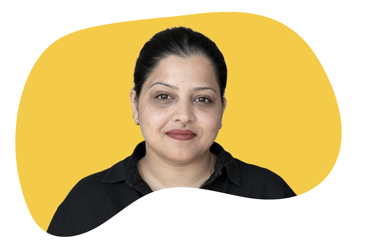 A woman with dark hair pulled back, wearing a black collared shirt, standing in front of a yellow and black background.