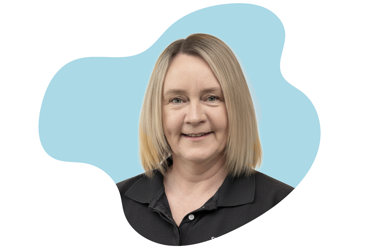 A woman with shoulder-length blonde hair smiling wearing a black collared shirt, with a blue background.