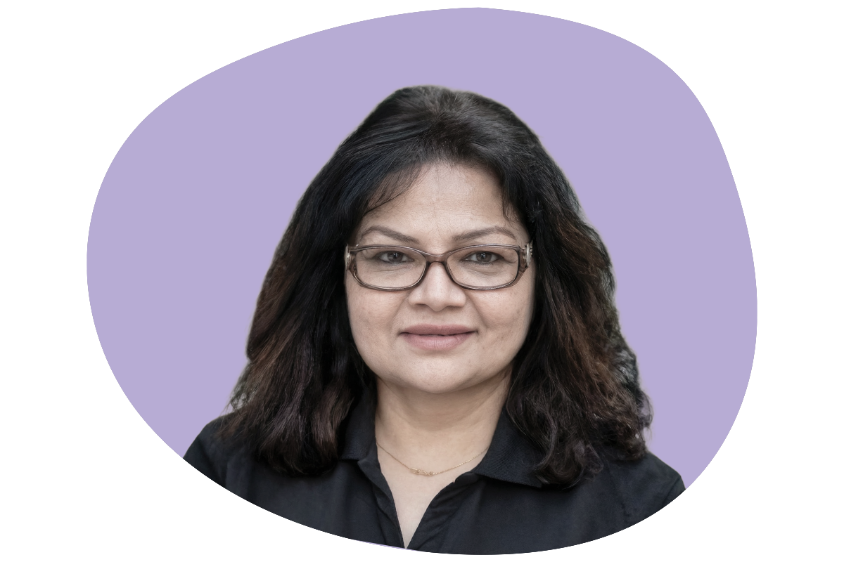 Headshot of a woman with dark, shoulder-length hair and glasses, wearing a black top, in front of a purple background.