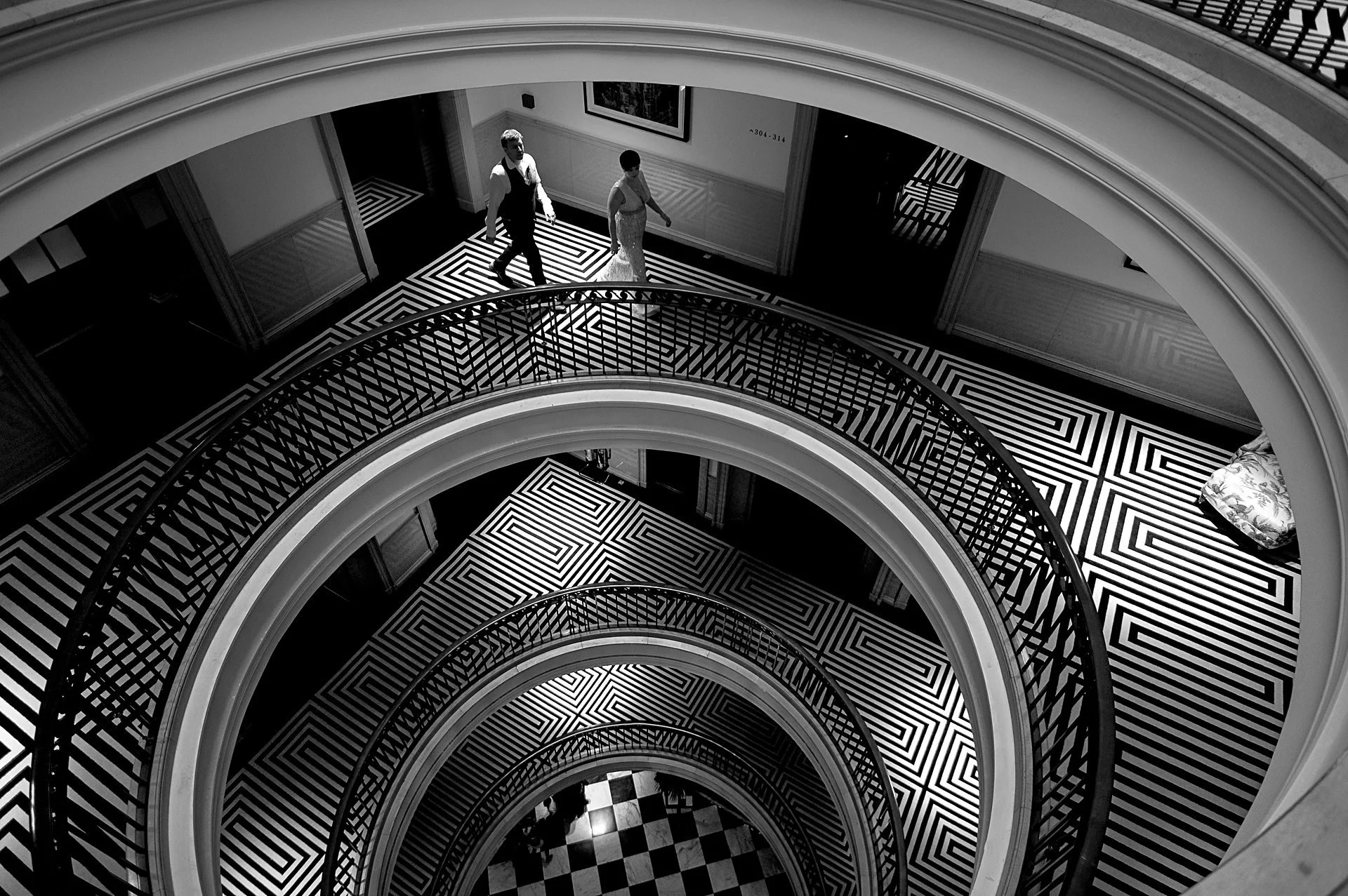 Couple in the curved black-and-white atrium at The Edinburgh Grand, Edinburgh