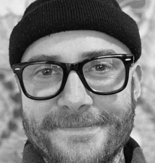 Close-up of a man with glasses, a beanie, and a beard.