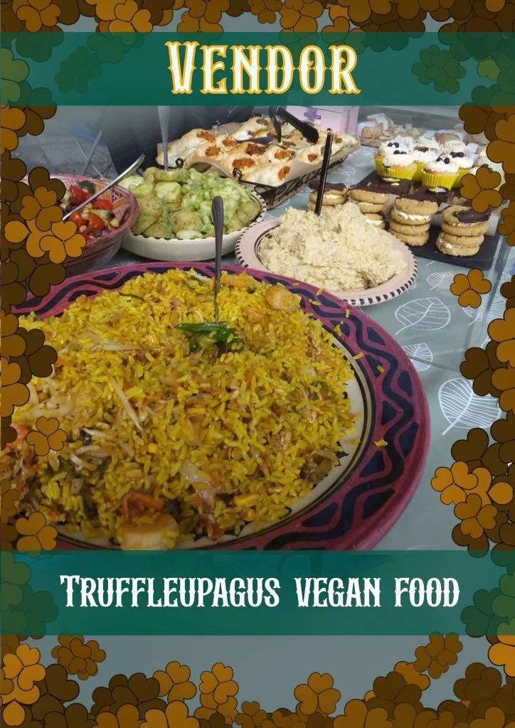 A table with various vegan foods, including a large plate of yellow fried rice with vegetables and possibly avocado salad, and several plates of desserts such as cookies and cake, labeled as 'VENDOR' and 'TRUFFLEUPAGUS VEGAN FOOD'.