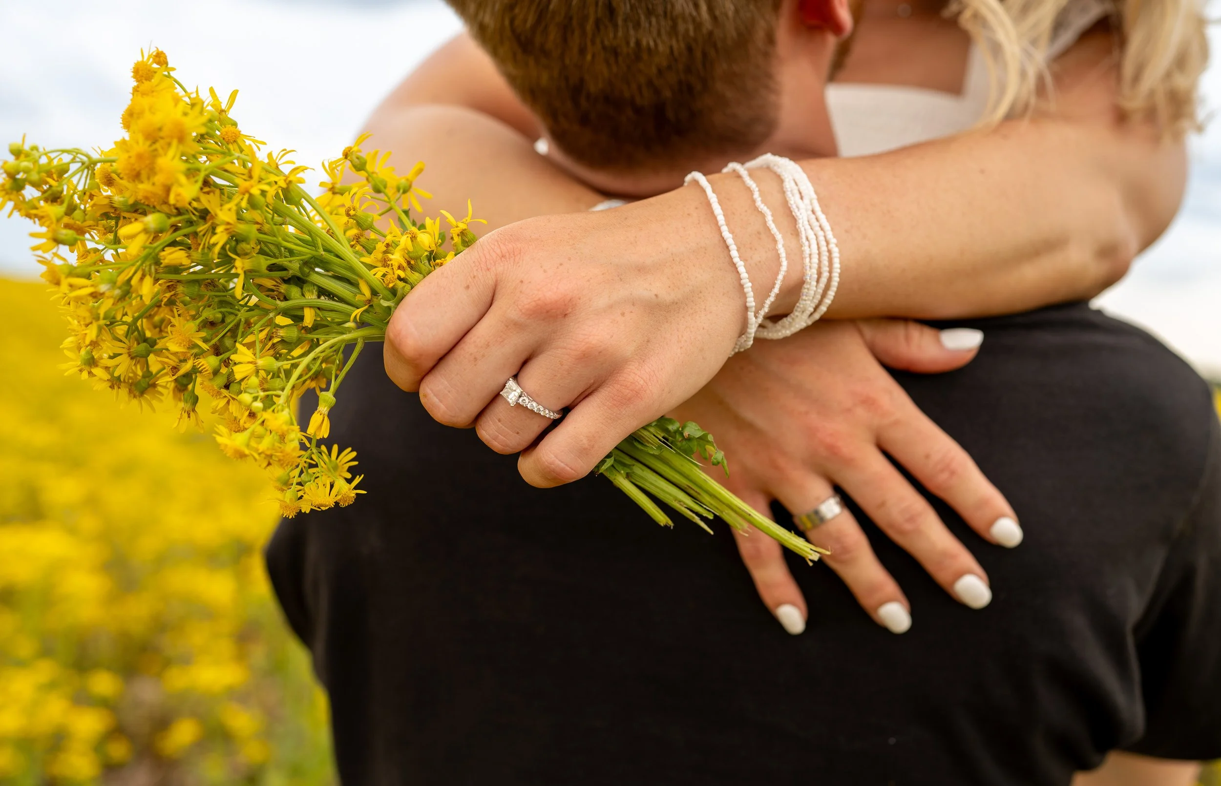 Evie Sronce_ family photography_ engagement ring with yellow flowers.jpg