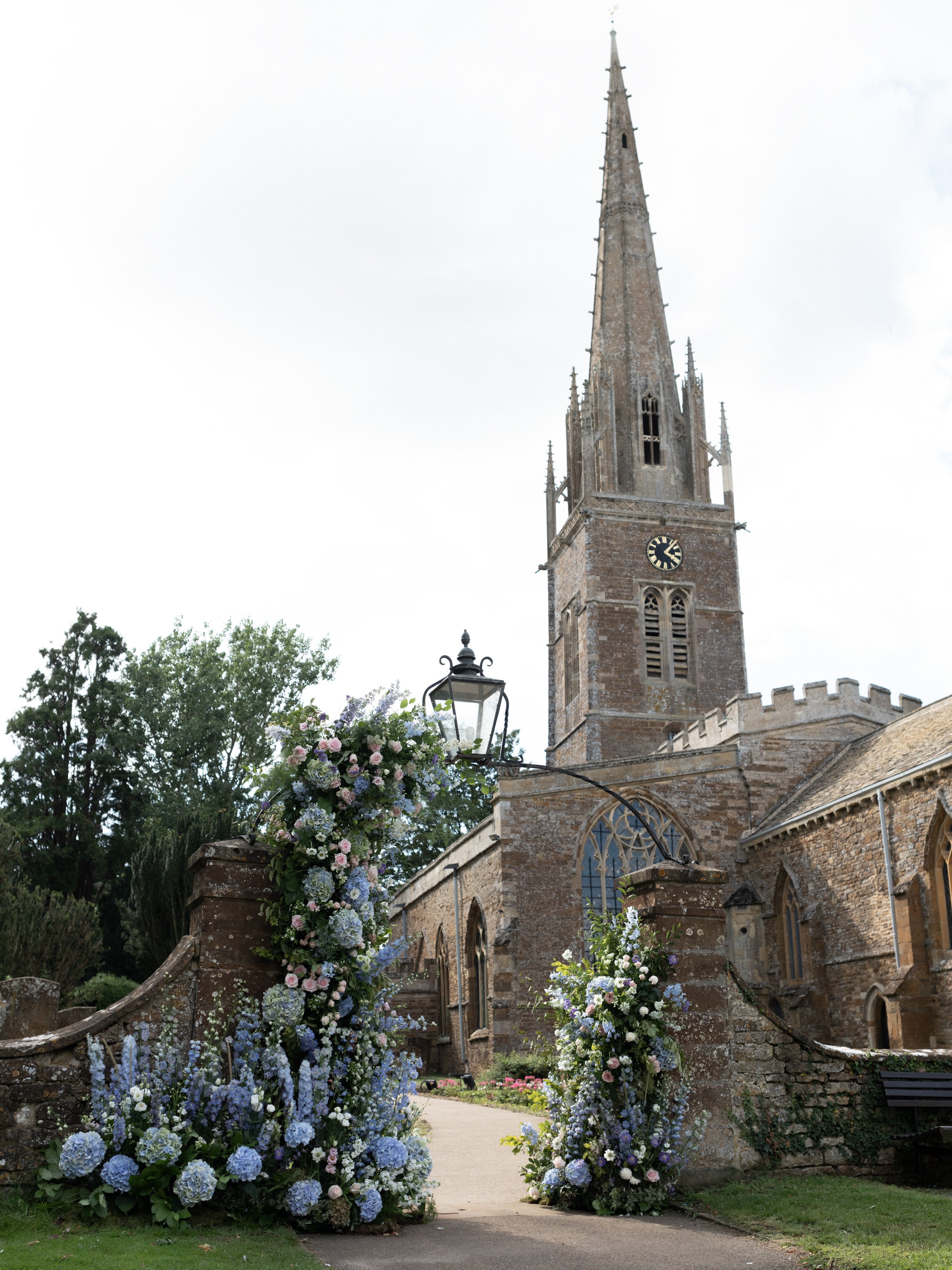 luxury cotswolds wedding planner, cotswolds church covered in flowers