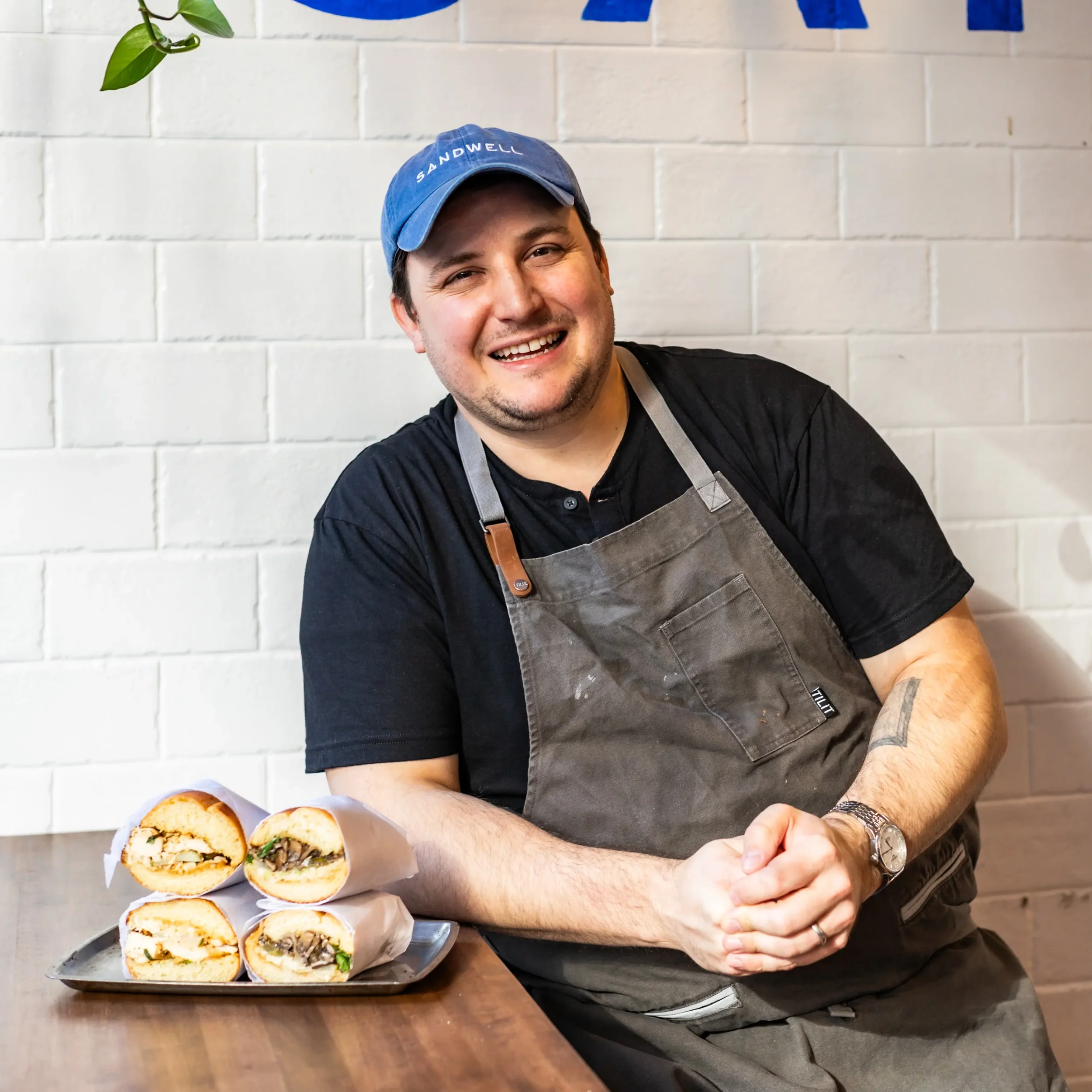 Andy Gottlieb, fundador y director ejecutivo de Sandwell, con una bandeja de sándwiches exclusivos elaborados con pan de sémola horneado en el propio local, en Sandwell, Nueva York