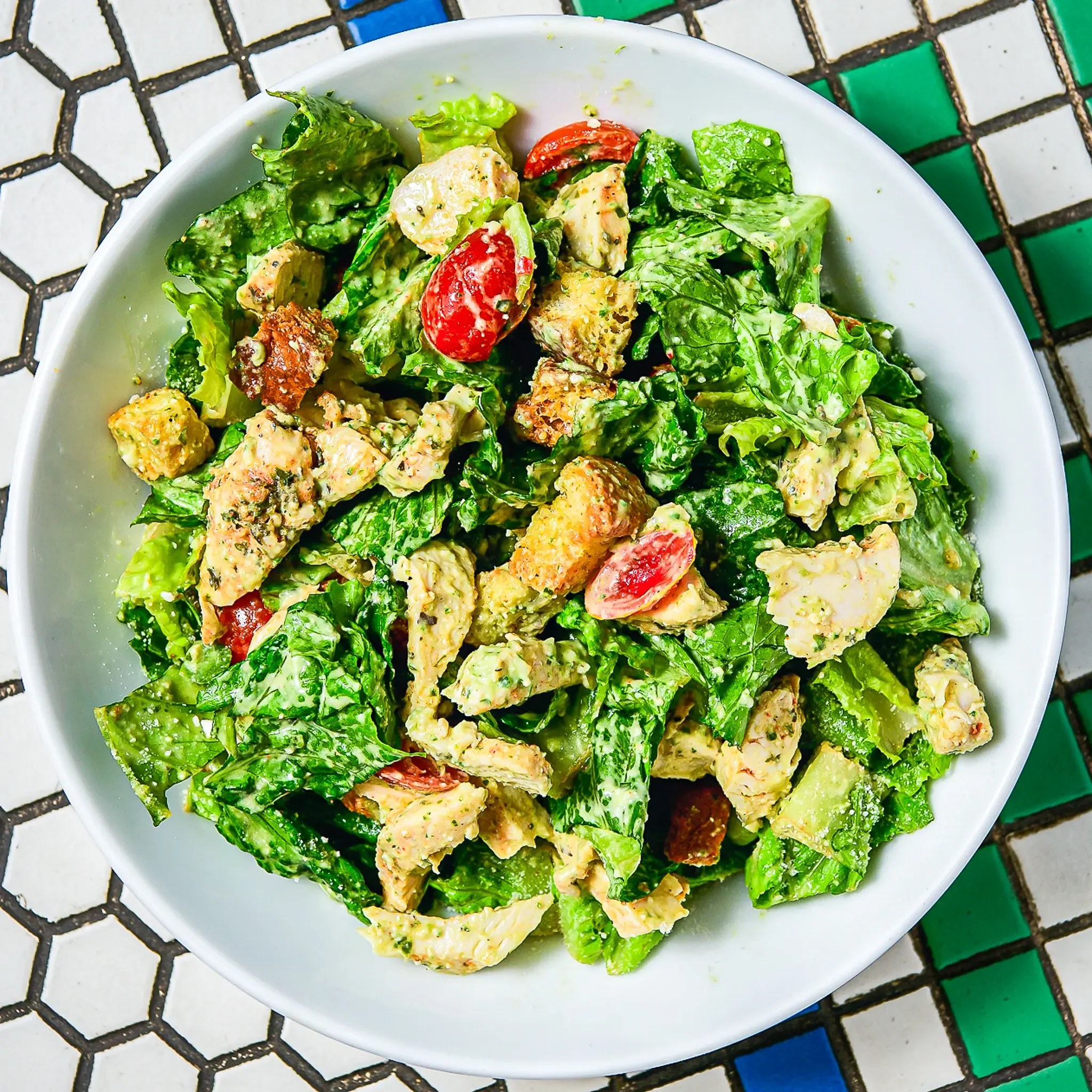 Sandwell's Green Goddess Chicken Caesar Salad — grilled chicken breast with romaine, parmesan, green goddess caesar dressing, parmesan croutons, and cherry tomatoes, available at Sandwell sandwich shops in NYC