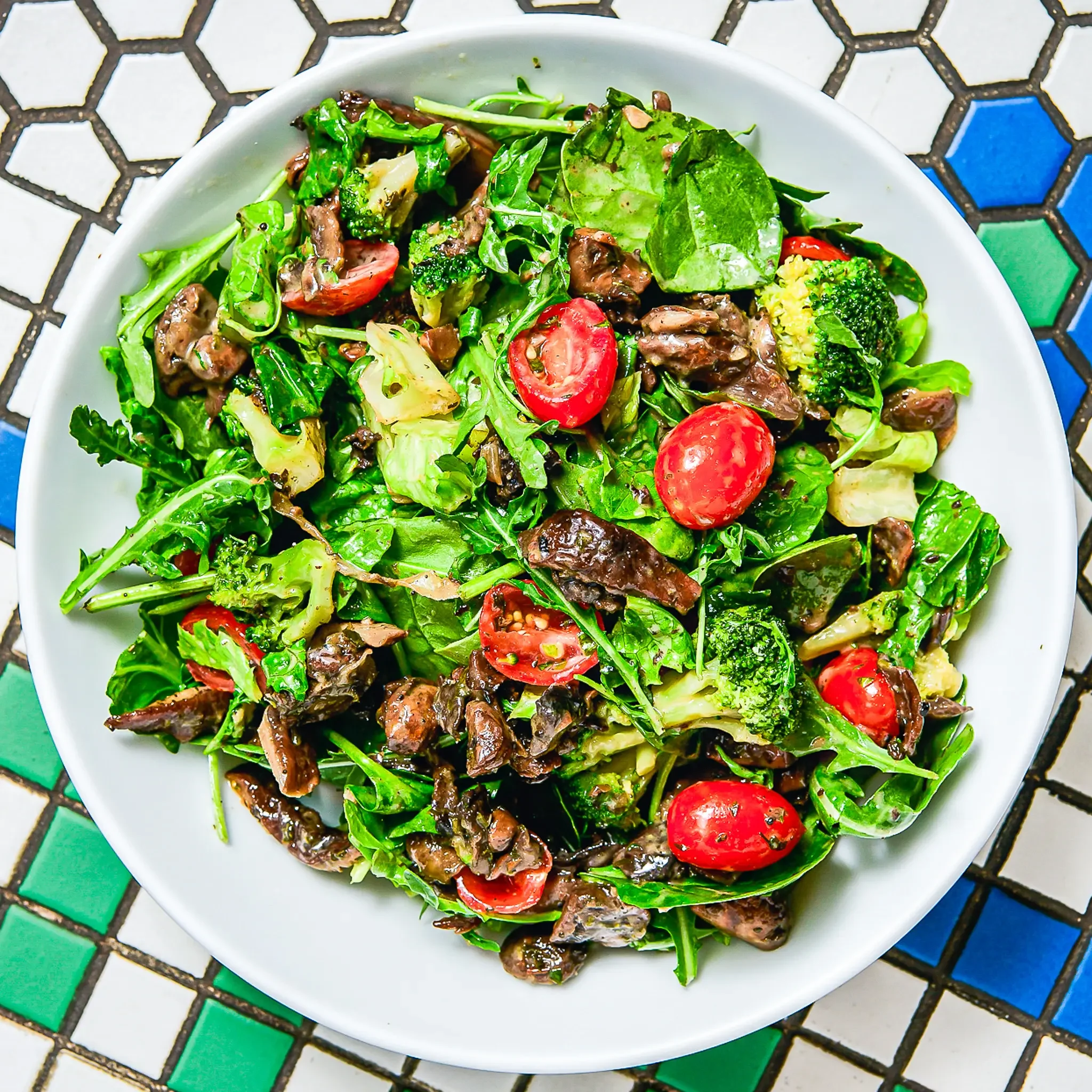 Sandwell's Truffled Mushroom Salad — a vegan salad with truffled roasted mushrooms, broccoli, cherry tomatoes, mixed greens, and maple dijon vinaigrette, available at Sandwell sandwich shops in NYC