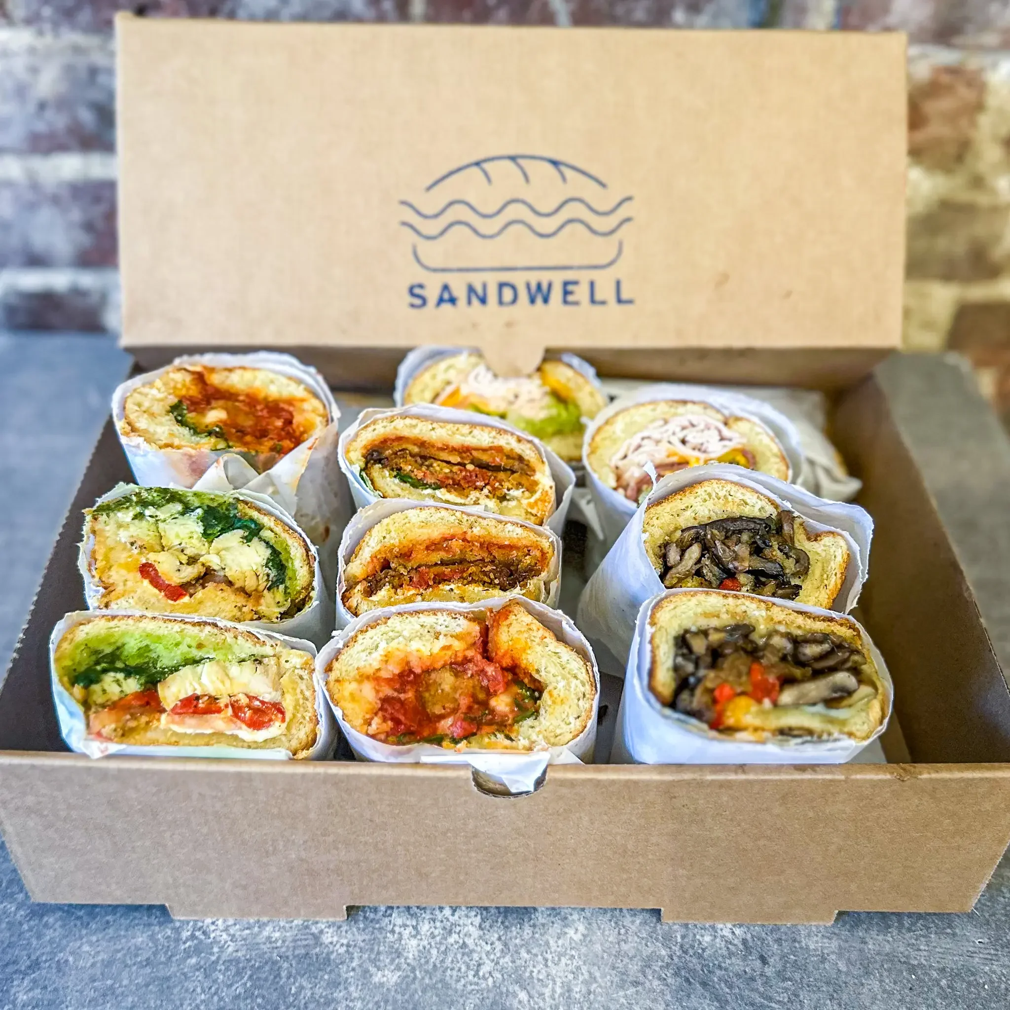Sandwell's Greatest Hits Sandwich Box for catering — featuring Chicken Pesto Burrata, Turkey Meatball Sub, Lunchbox Special, Spicy Eggplant Parm, and Mushroom Cheese"steak", available in NYC