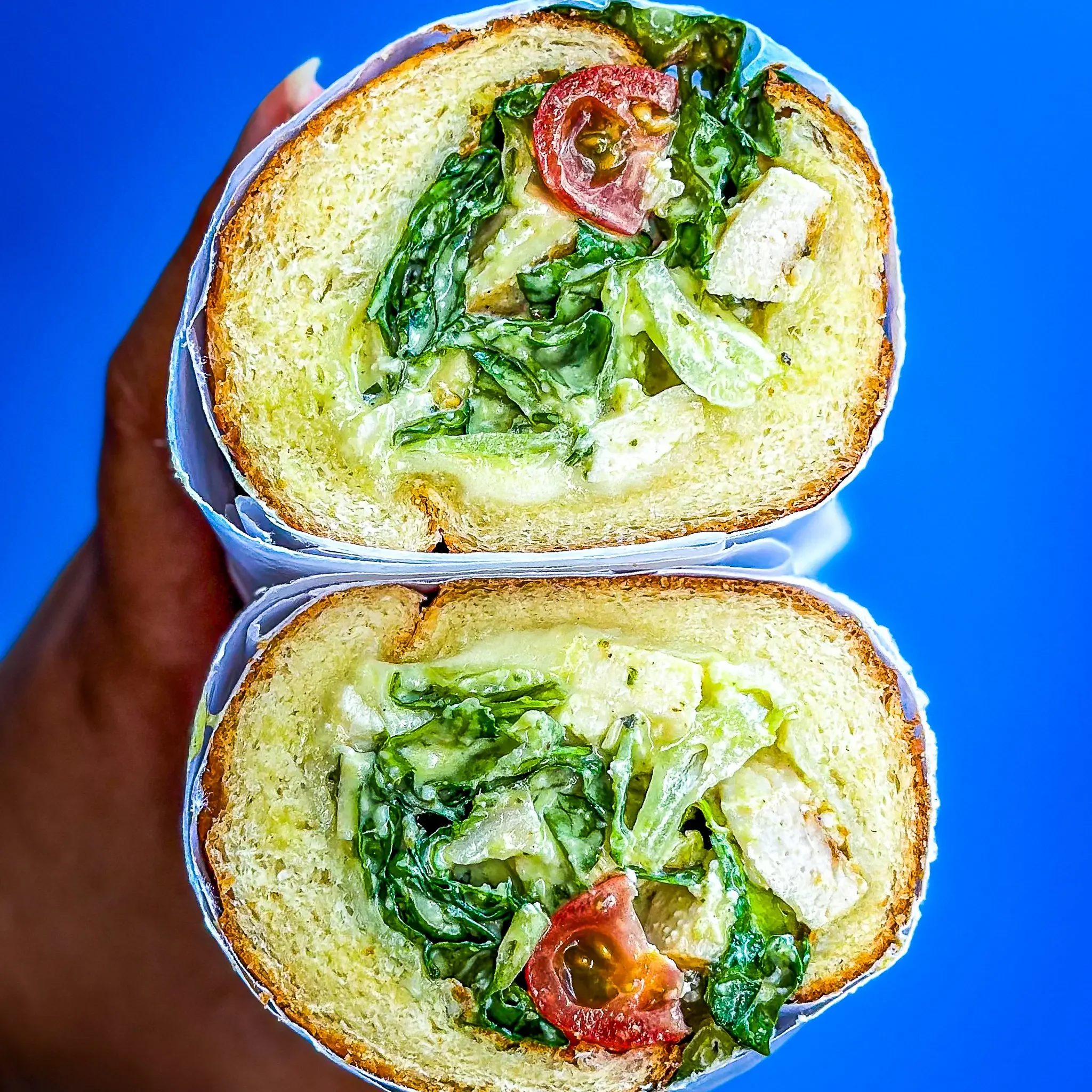 Sandwell's Green Goddess Chicken Caesar Sub — grilled chicken with green goddess caesar dressing, parmesan, romaine, cherry tomato, and provolone on a house-baked semolina roll, available at Sandwell sandwich shops in NYC