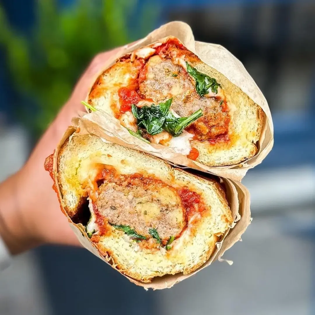 Sandwell's Turkey Meatball Sub — turkey meatballs in classic Sunday marinara sauce with provolone, parmesan, basil oil, and arugula on a house-baked semolina roll, available at Sandwell sandwich shops in NYC