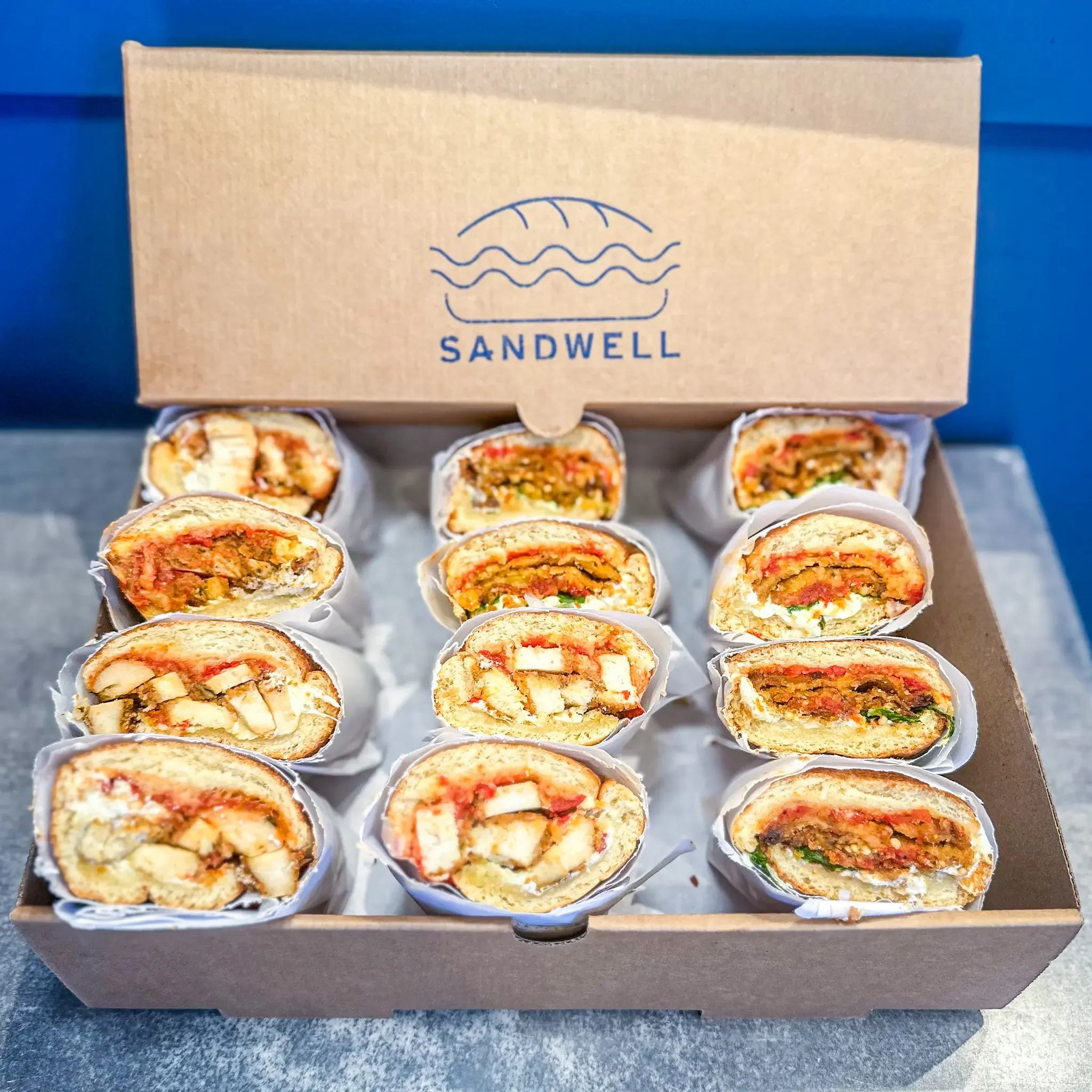 Sandwell's Parms Sandwich Box for catering — featuring Chicken Parm and Spicy Eggplant Parm subs with whipped burrata on house-baked semolina bread, available in NYC