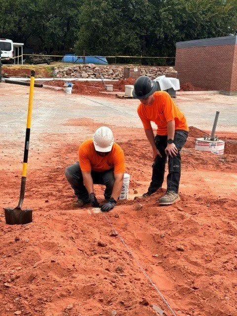 Two electricians pulling wire outside