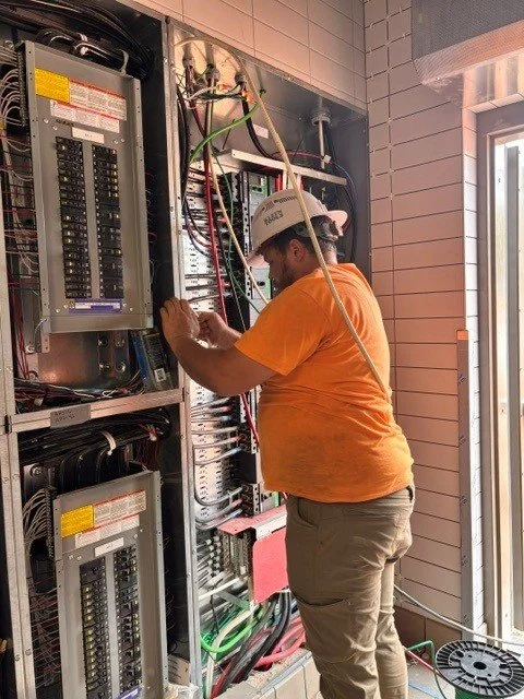 An electrician working to straighten a wire
