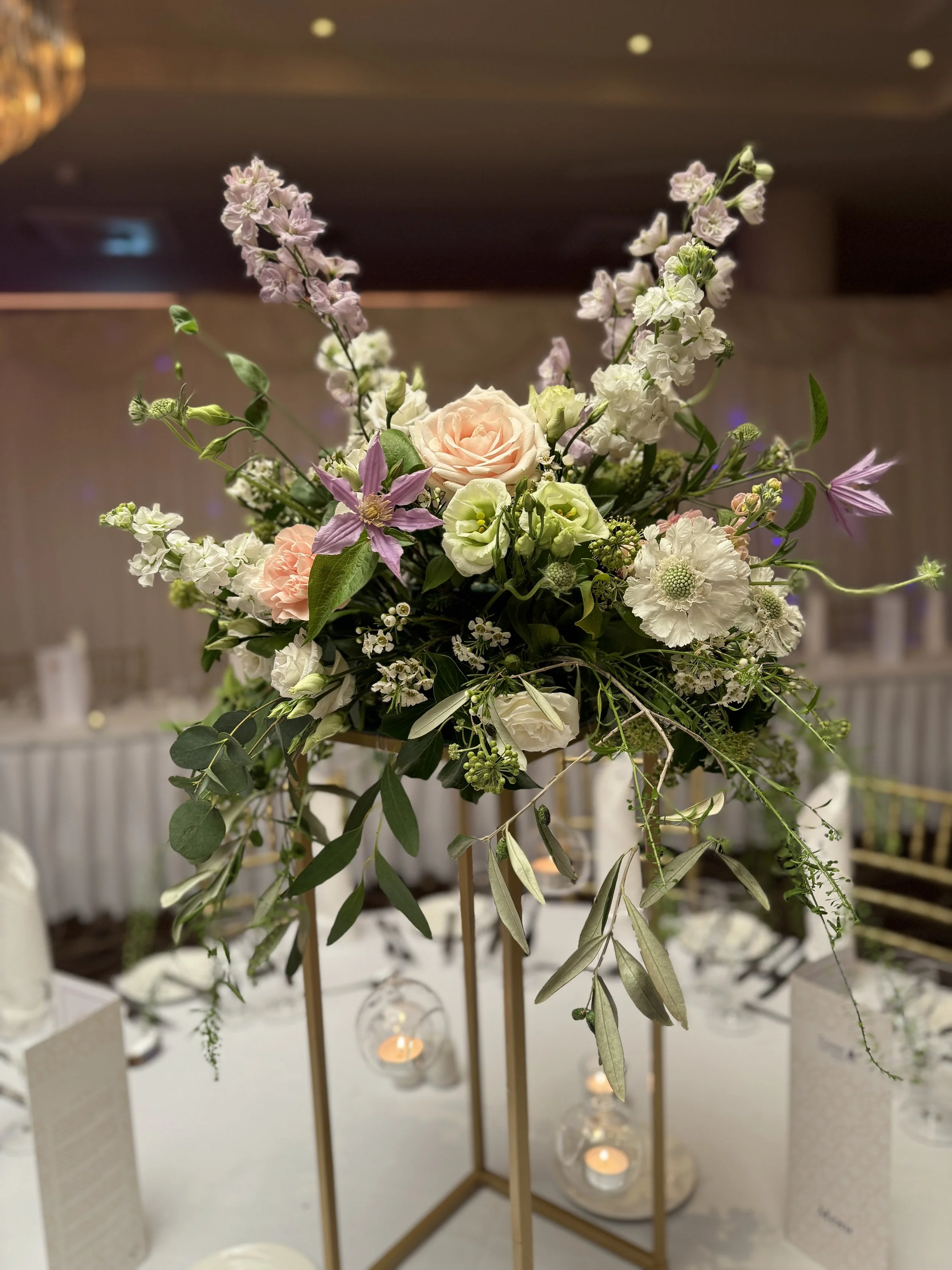Gold stand centrepiece with hanging floating candles.
