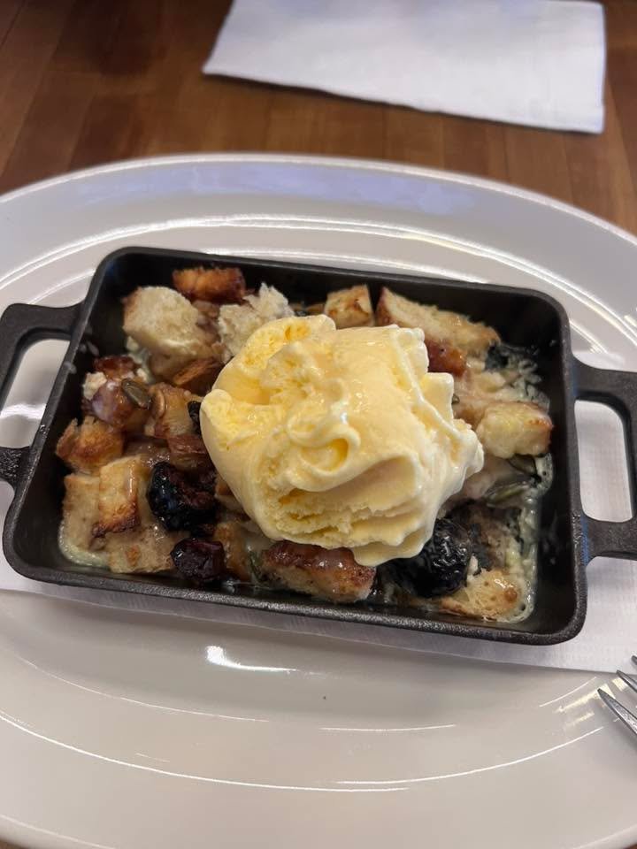 Served dish of bread pudding with vanilla ice cream on top