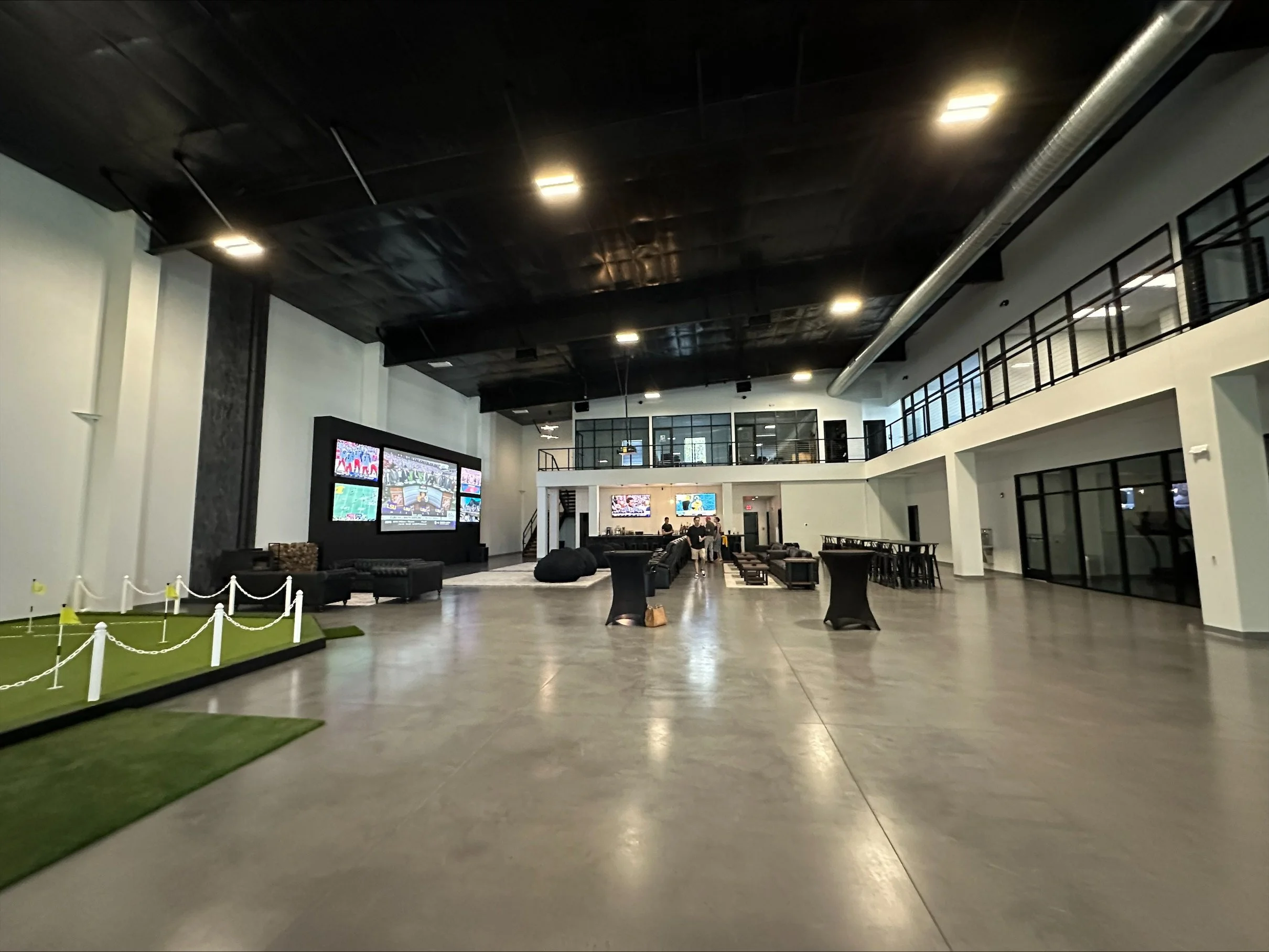 3 2024_09 Clear to Launch_Interior-big putting green-social space_screens-offices visible.jpg