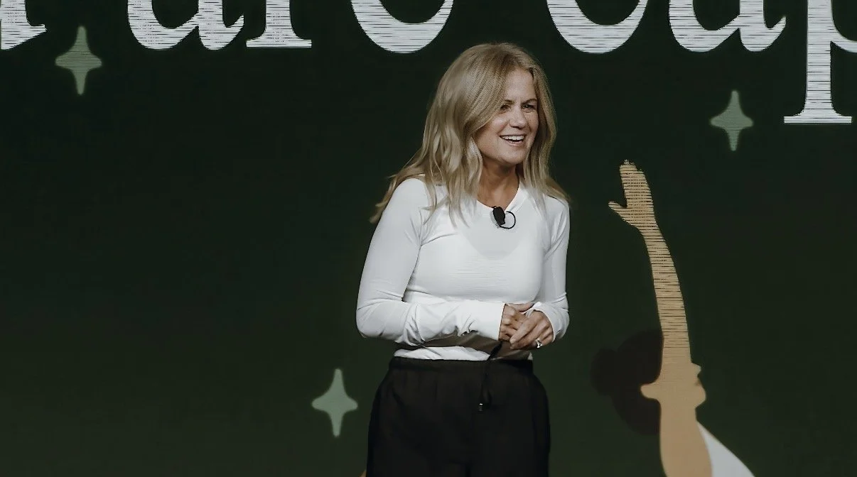 Charlotte Frederick speaking on stage at a Mindful Moments event.