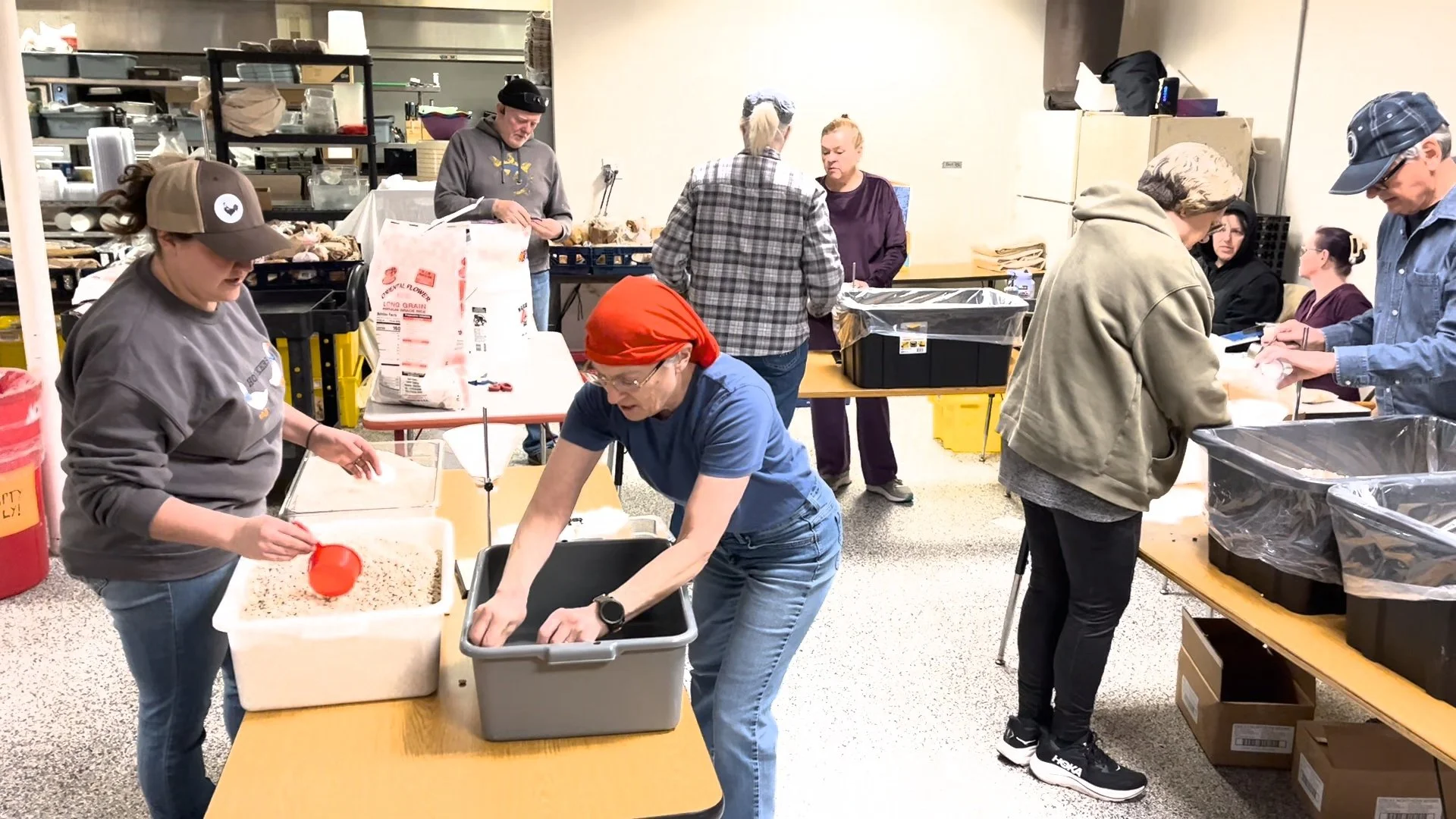 Volunteers working together to package Nobody Goes Hungry dry stew mixes.