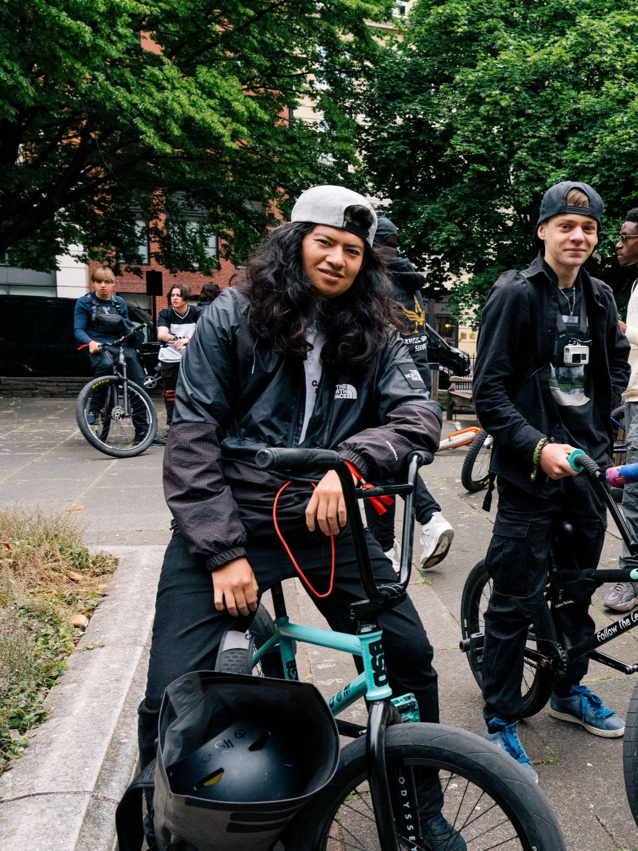 Group of bikers in urban setting with trees