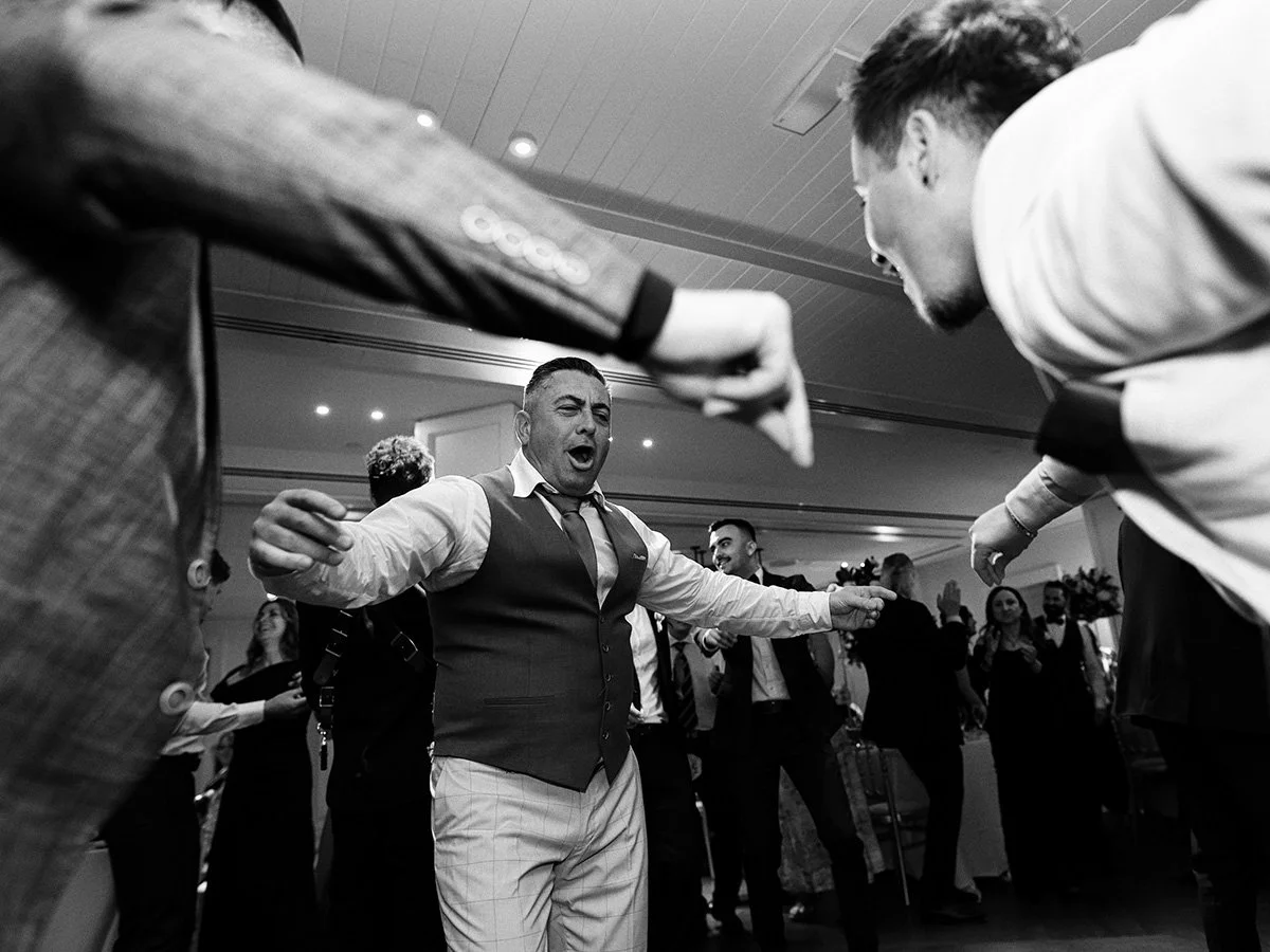 Fun dance floor moment with the groom and his friends celebrating at the wedding reception.