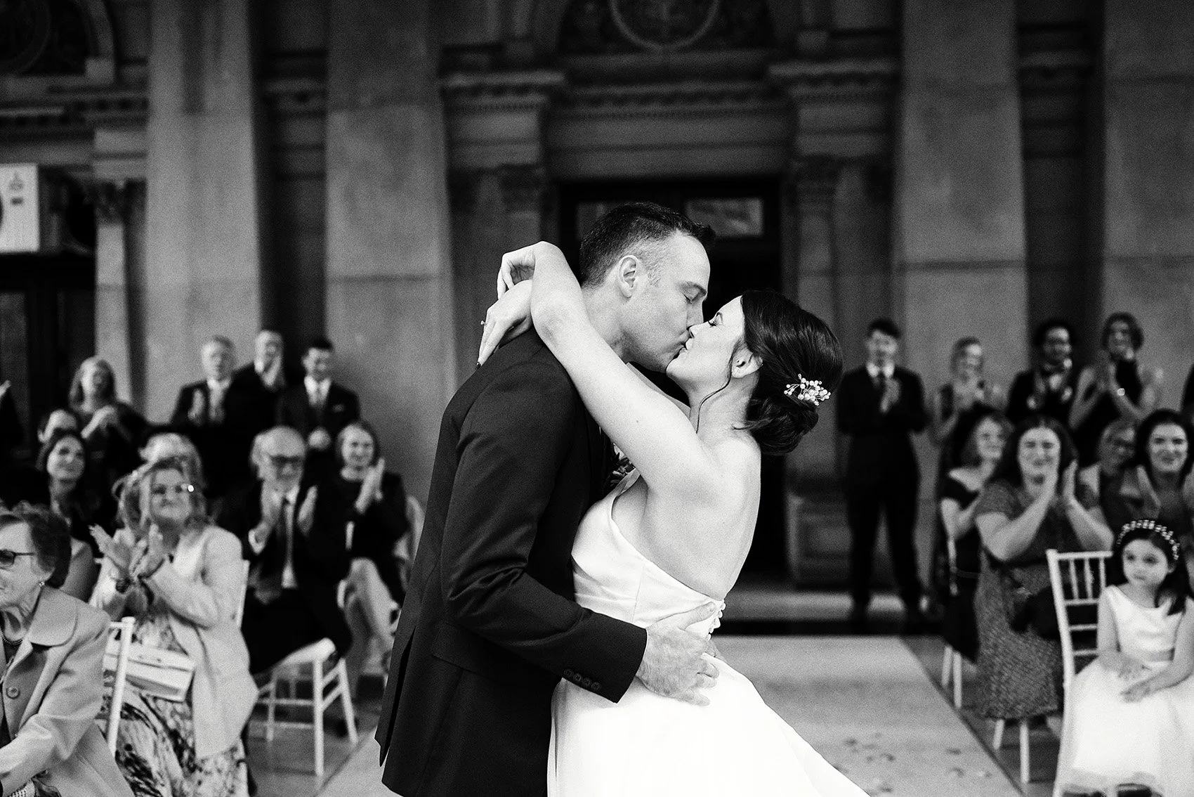 Black and white candid wedding ceremony kiss at Melbourne Town Hall, captured by Warren Photography.