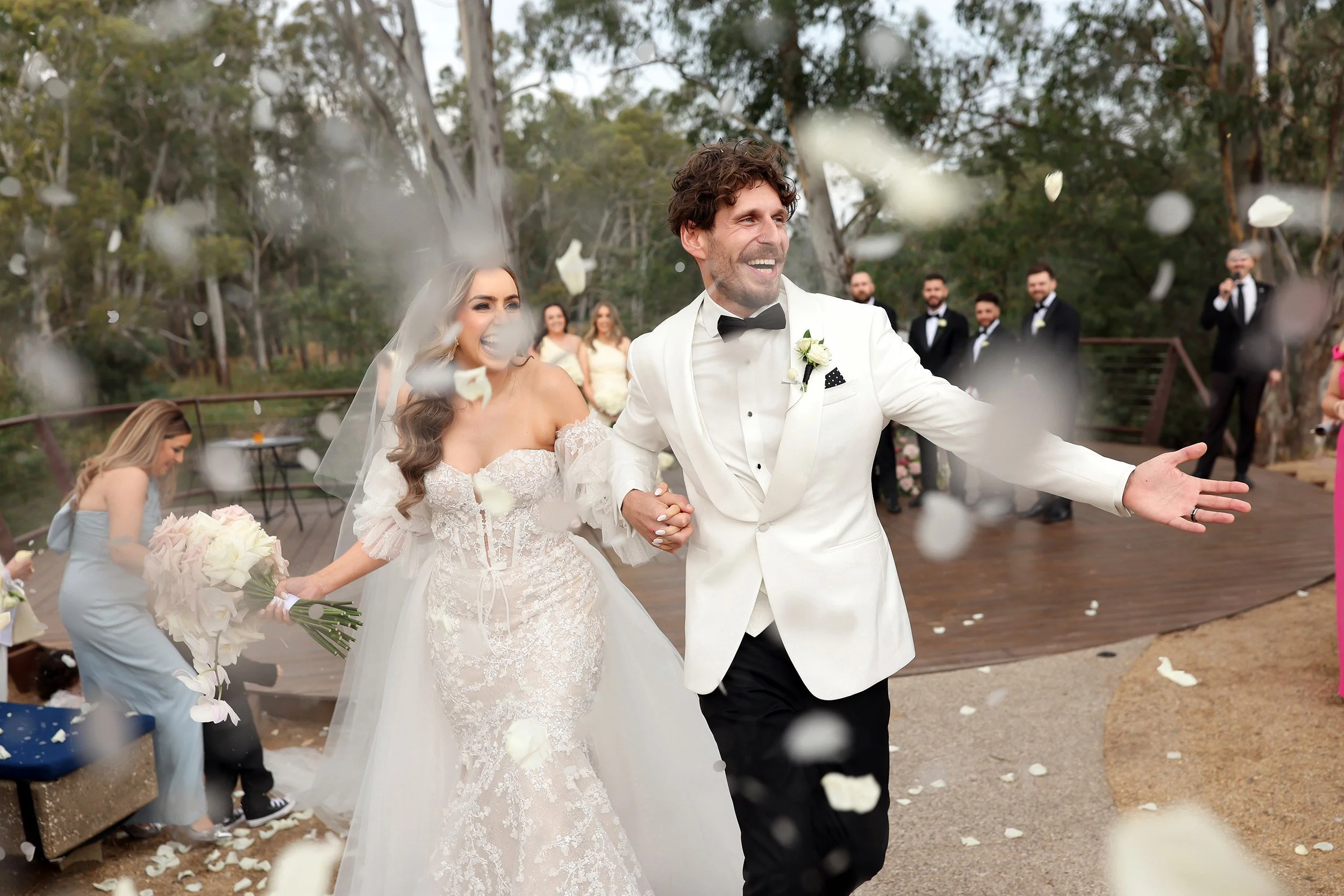 Bride and groom celebrating with champagne spray at Mitchelton Estate, candid moment captured by Melbourne wedding photographer