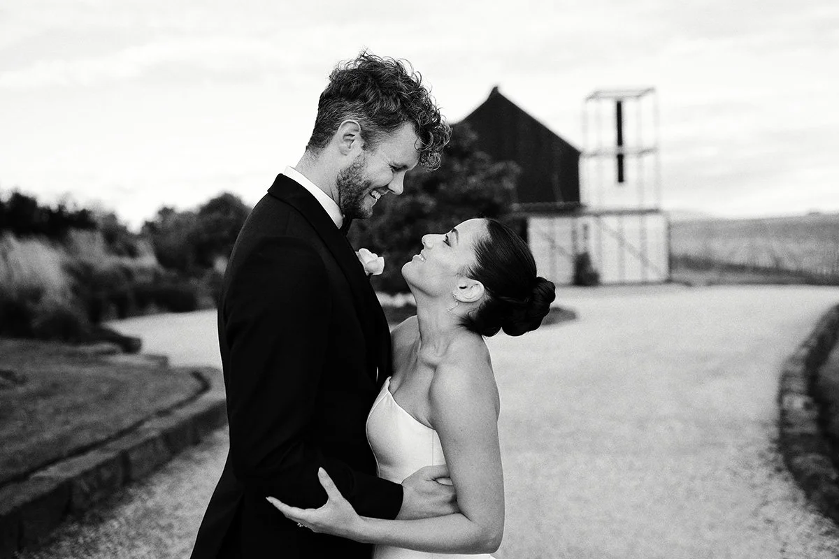 Couple embracing on the driveway at Zonzo Estate vineyard wedding