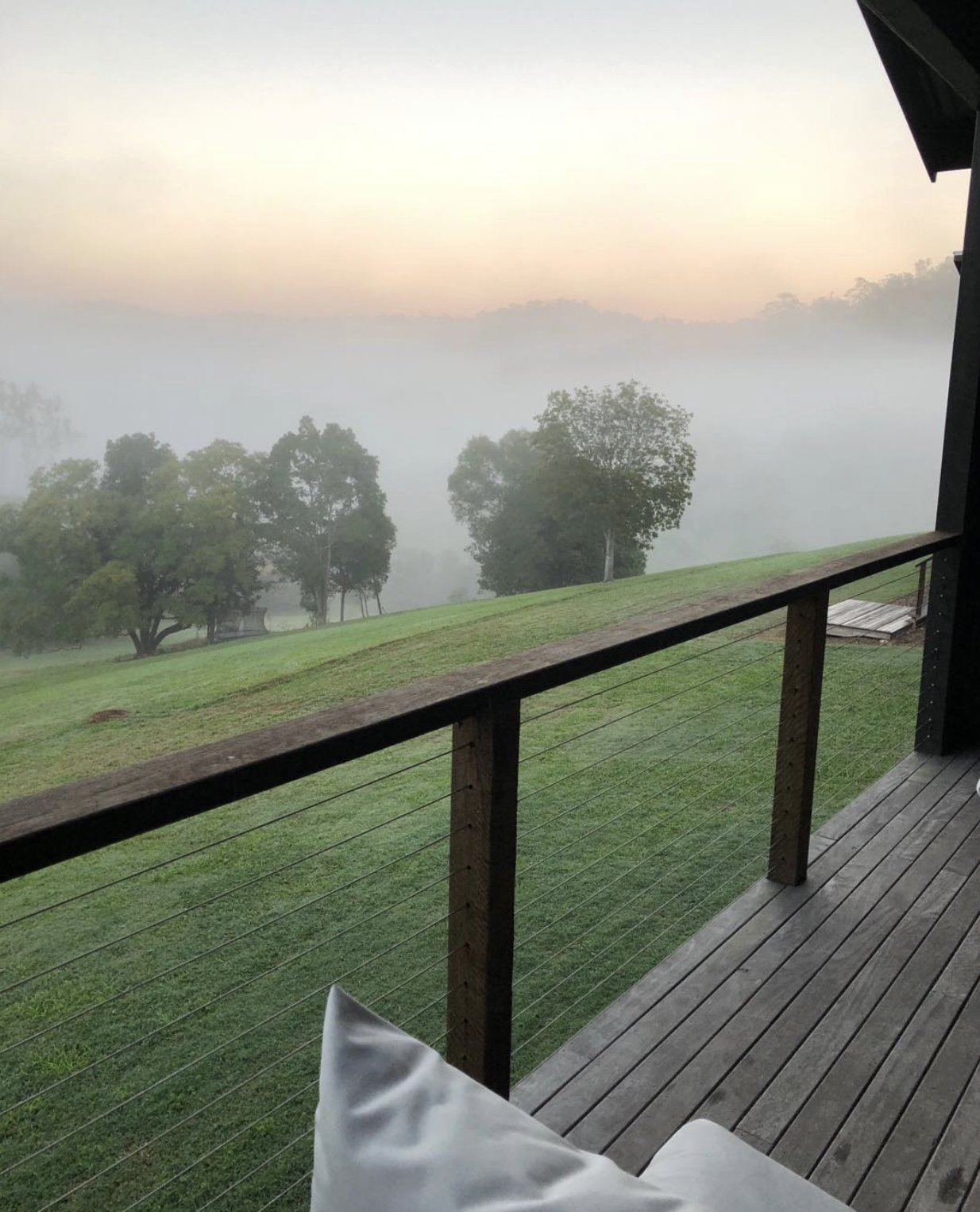 View of dawn mist sunrise over hills green lush grass