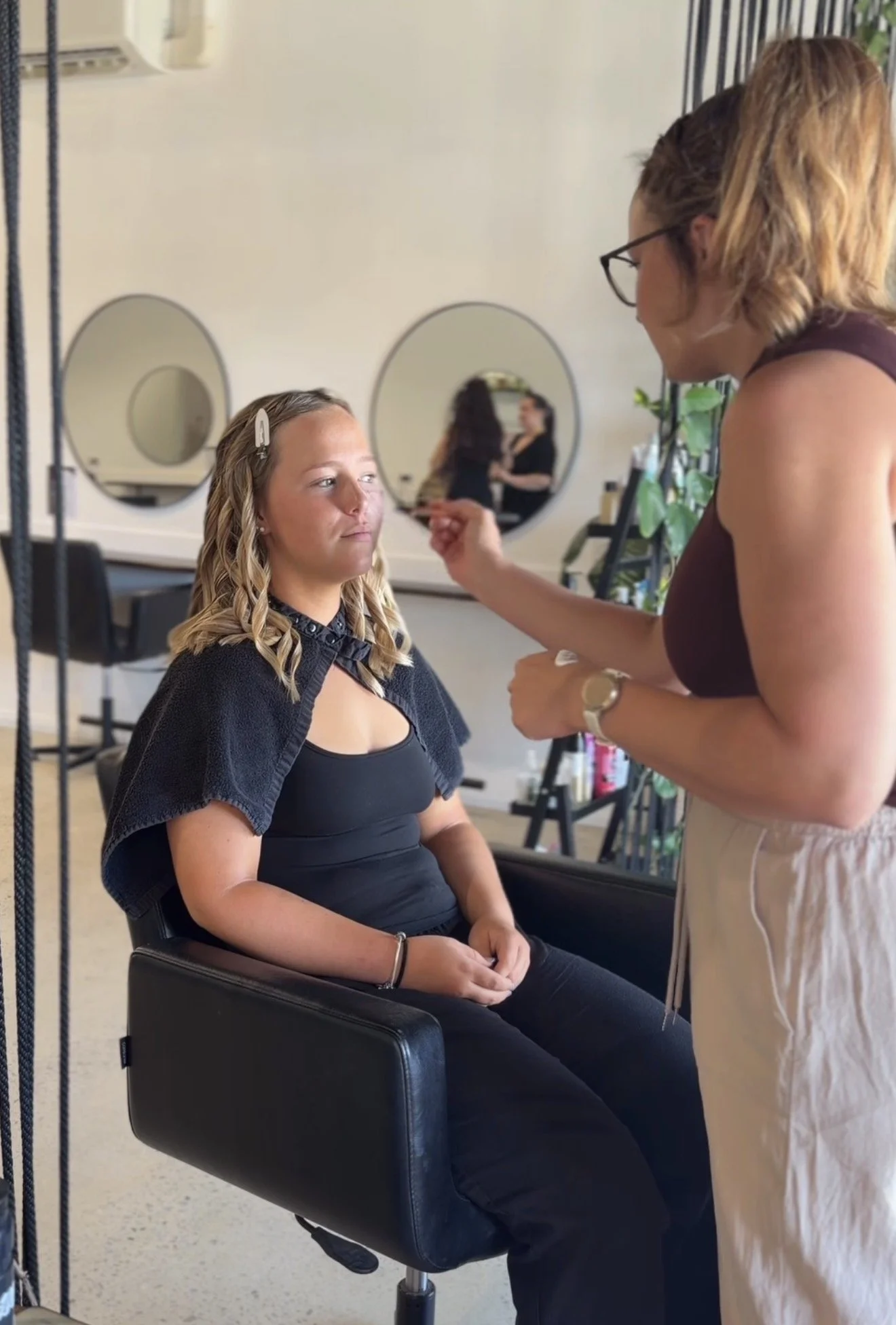 Three beige dried pampas grass stalks against a plain light beige background.