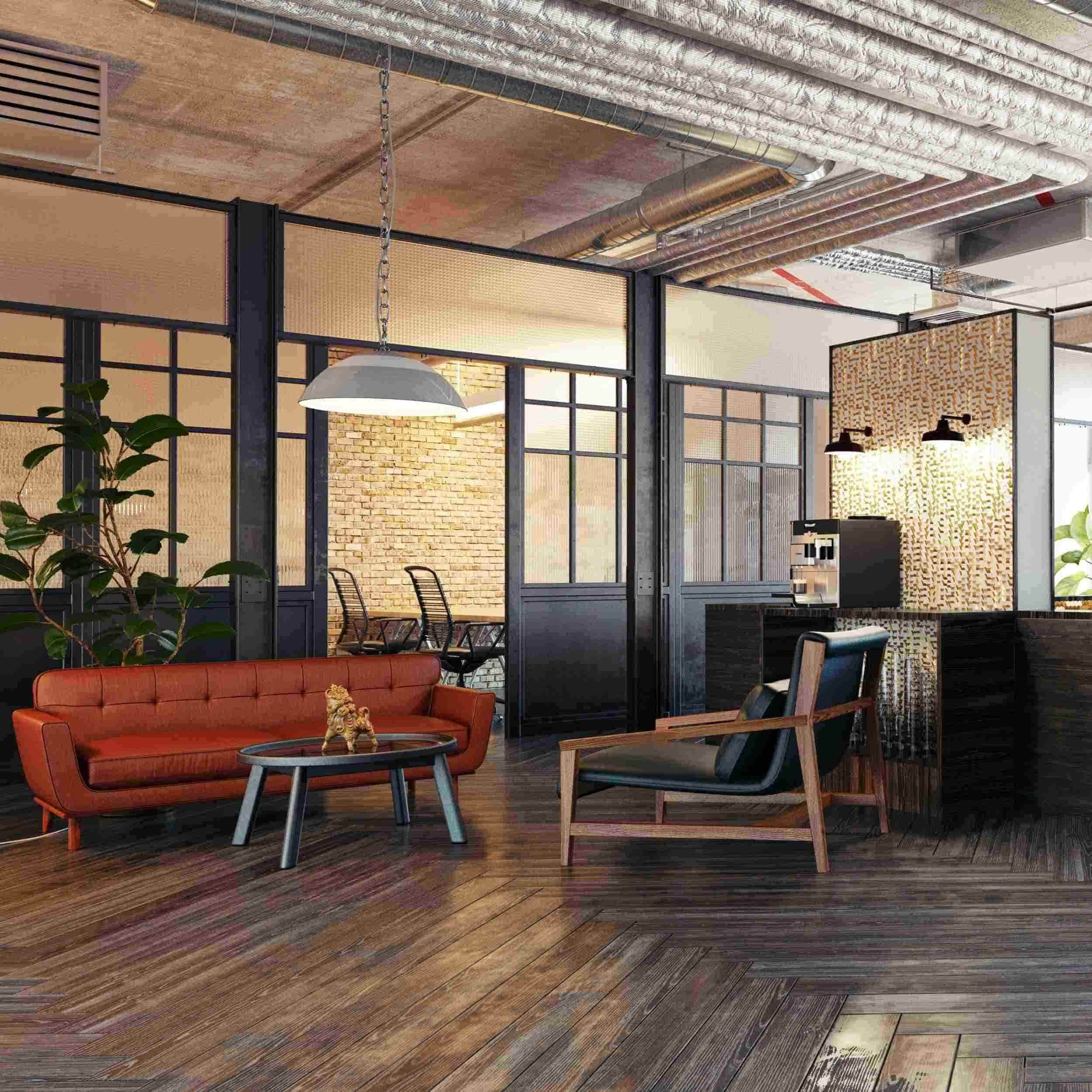 A modern lounge area with a red sofa, a black armchair, and a coffee table with a decorative lion statue. In the background are glass-paneled rooms, exposed brick walls, and an industrial ceiling with ductwork. There's a coffee machine on a counter and a large plant to the left.