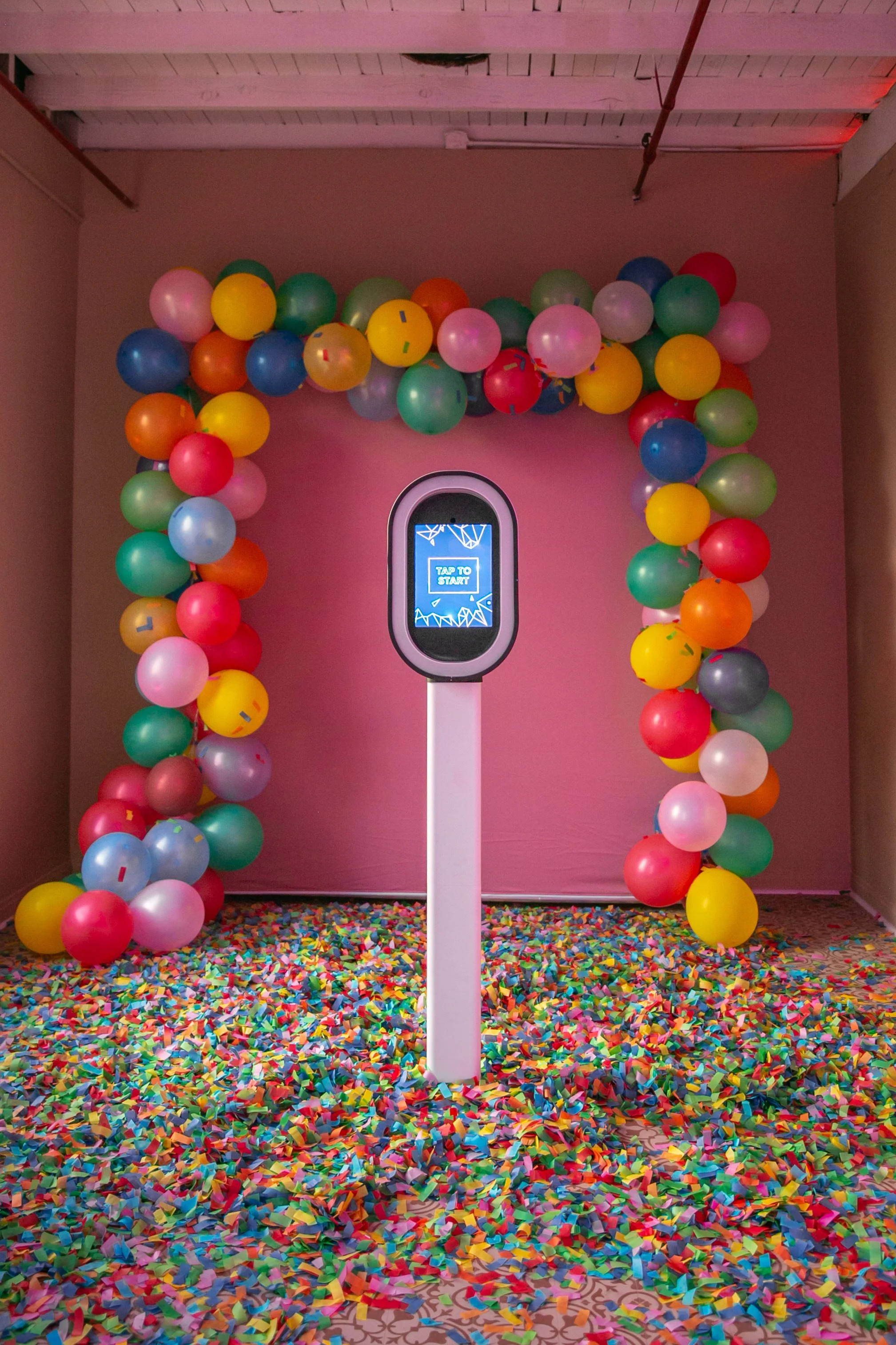 A party-ready digital photo booth setup featuring a balloon arch and confetti floor—perfect for birthdays, kids’ parties, and fun celebrations