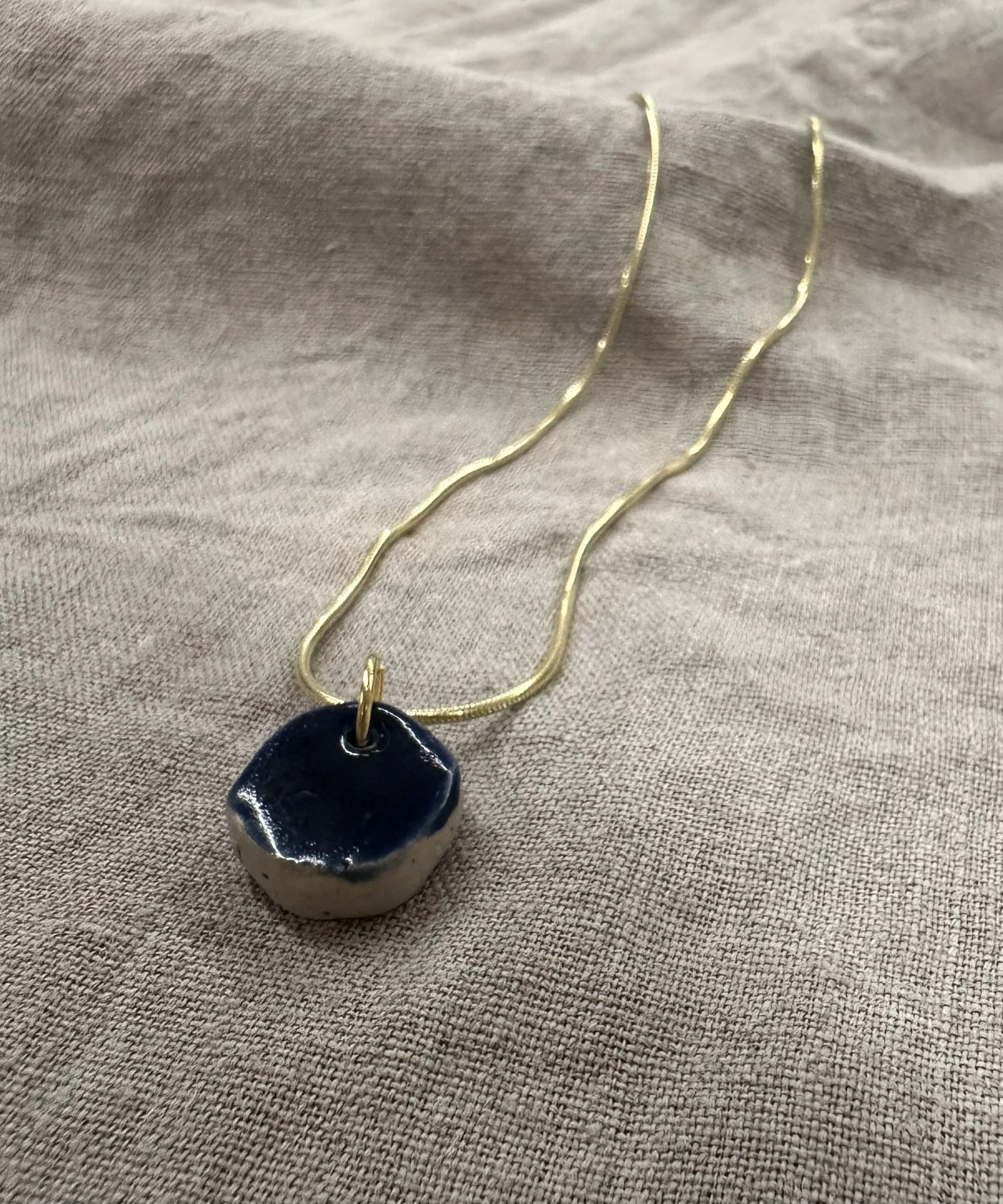 Goldene Kette mit dunkelblauem Anhänger