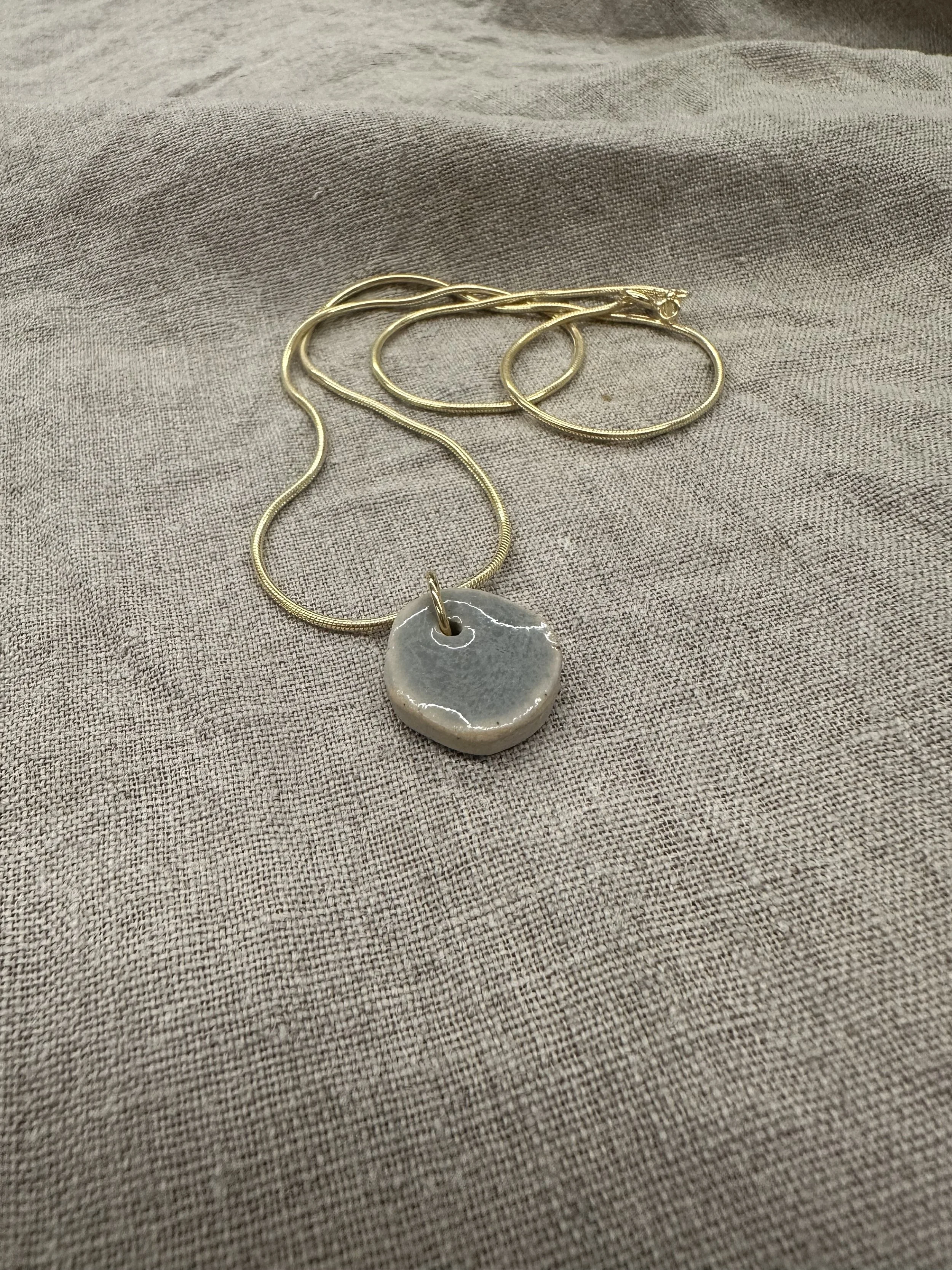 Goldene Kette mit grauem Anhänger