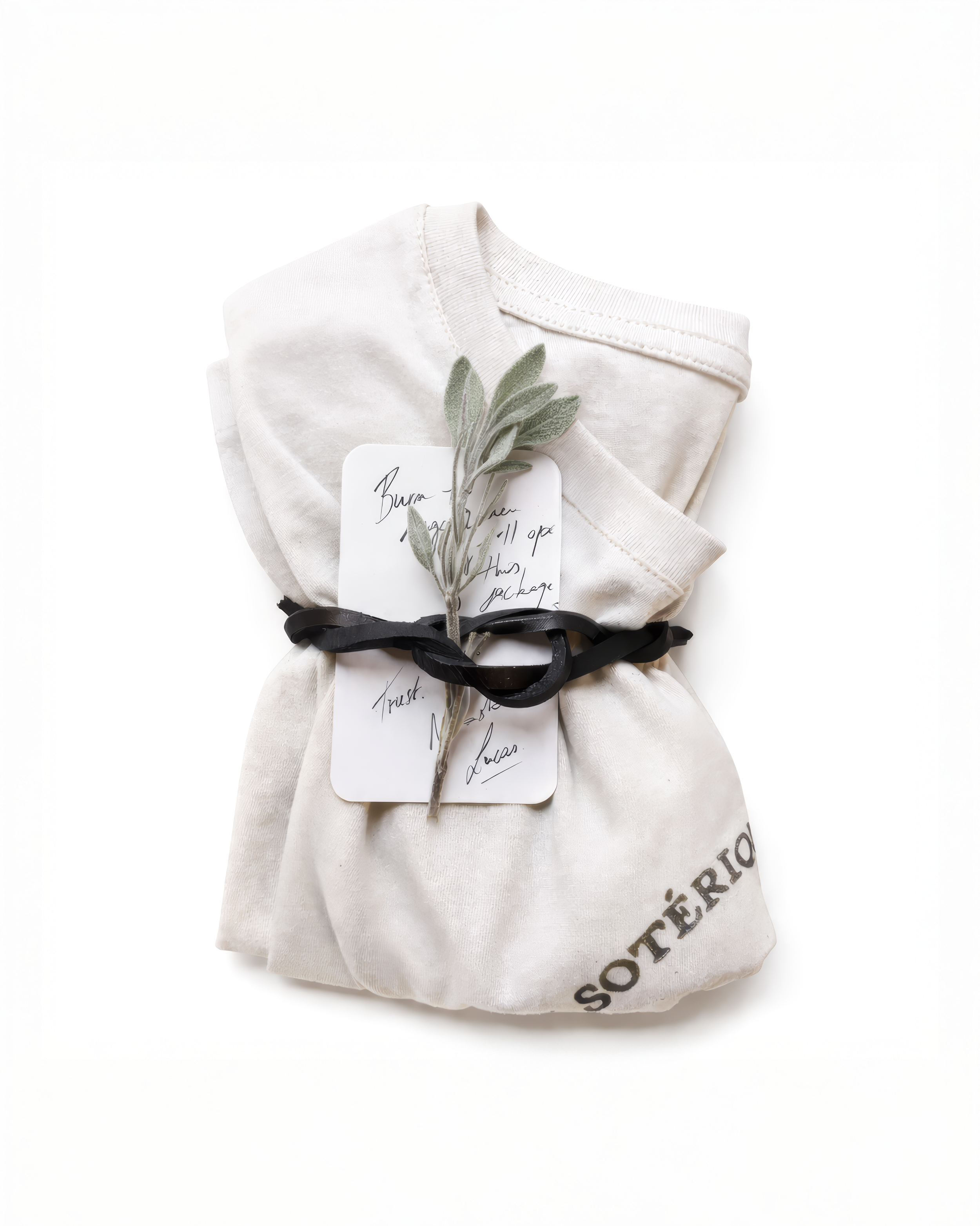Garment Presentation — Hand-Finished Assembly
A cotton t-shirt accompanied by a handwritten thank-you card, secured with a leather tie and finished with a white sage branch.