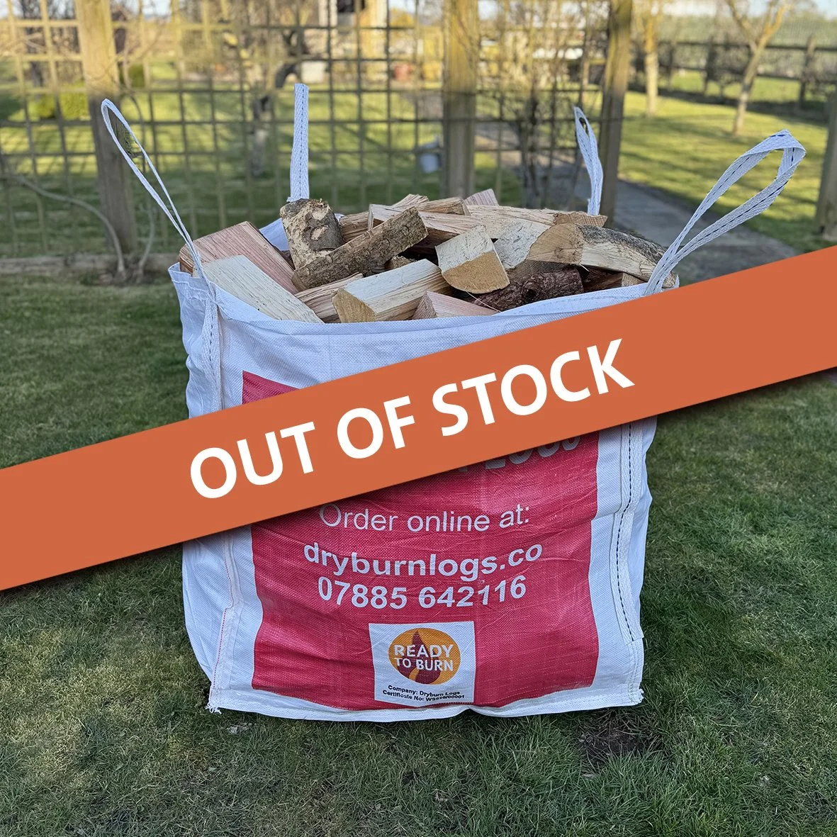 Large bag of chopped firewood labeled 'DRYBURN LOGS' with ordering information, placed outdoors on grass.