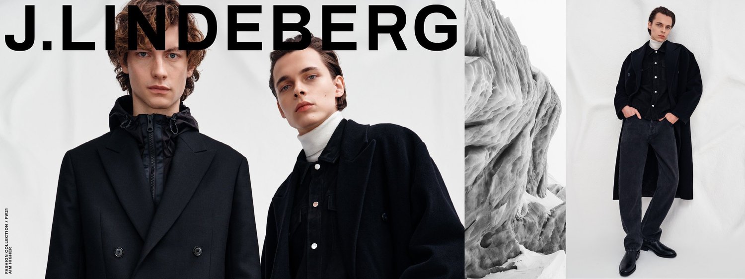 Fashion models in black and dark clothing posing in front of a white background, with a large black text that reads "J.LINDERBERG" and a black and white marble sculpture.