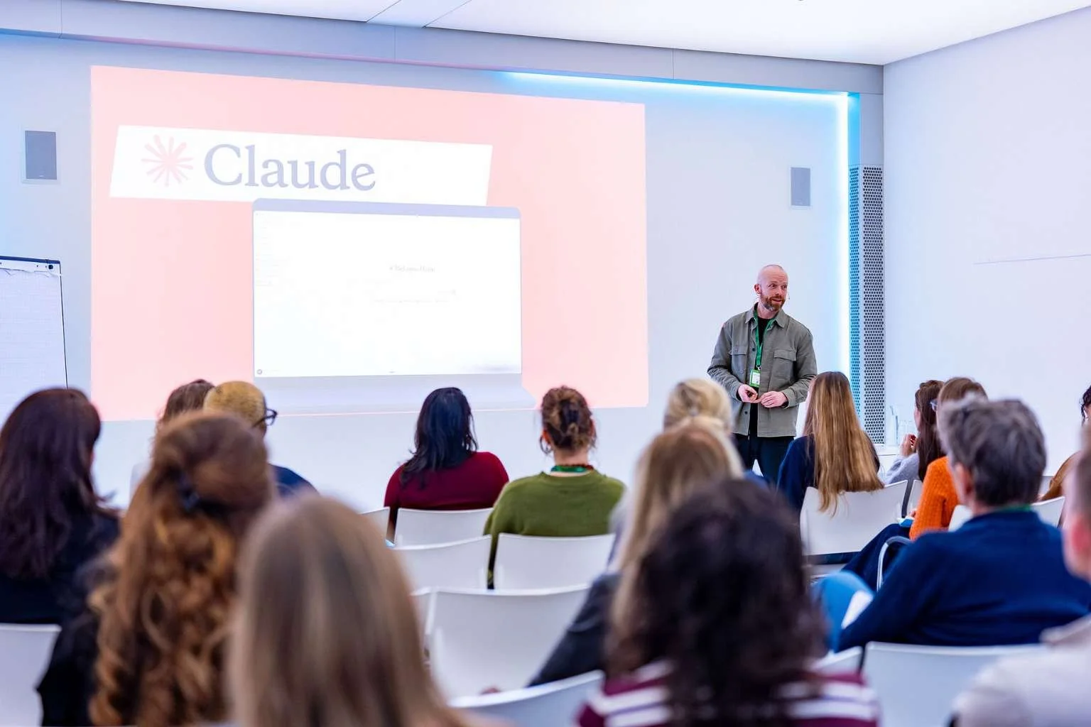 Man geeft presentatie voor groep mensen in een moderne conferentiezaal.