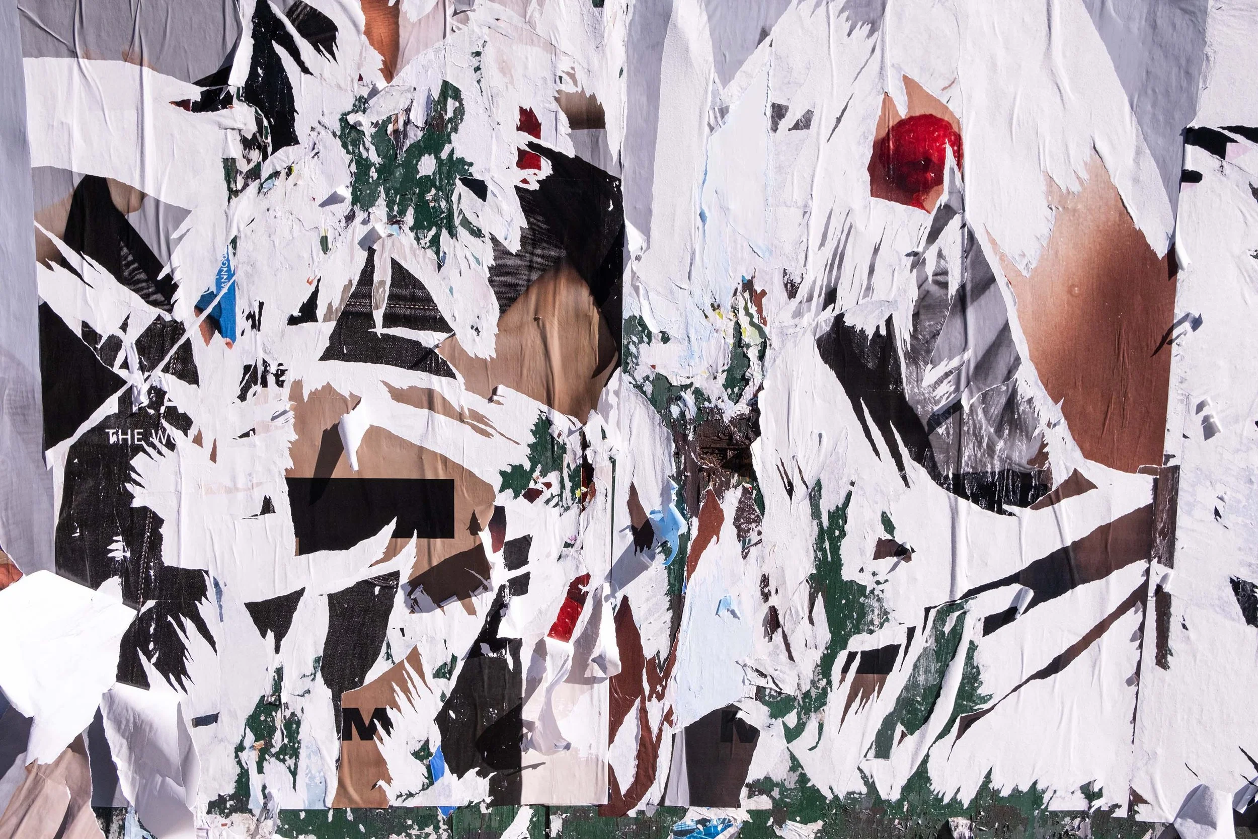 Collage of torn paper pieces forming images of a person's face, text, and various colors.