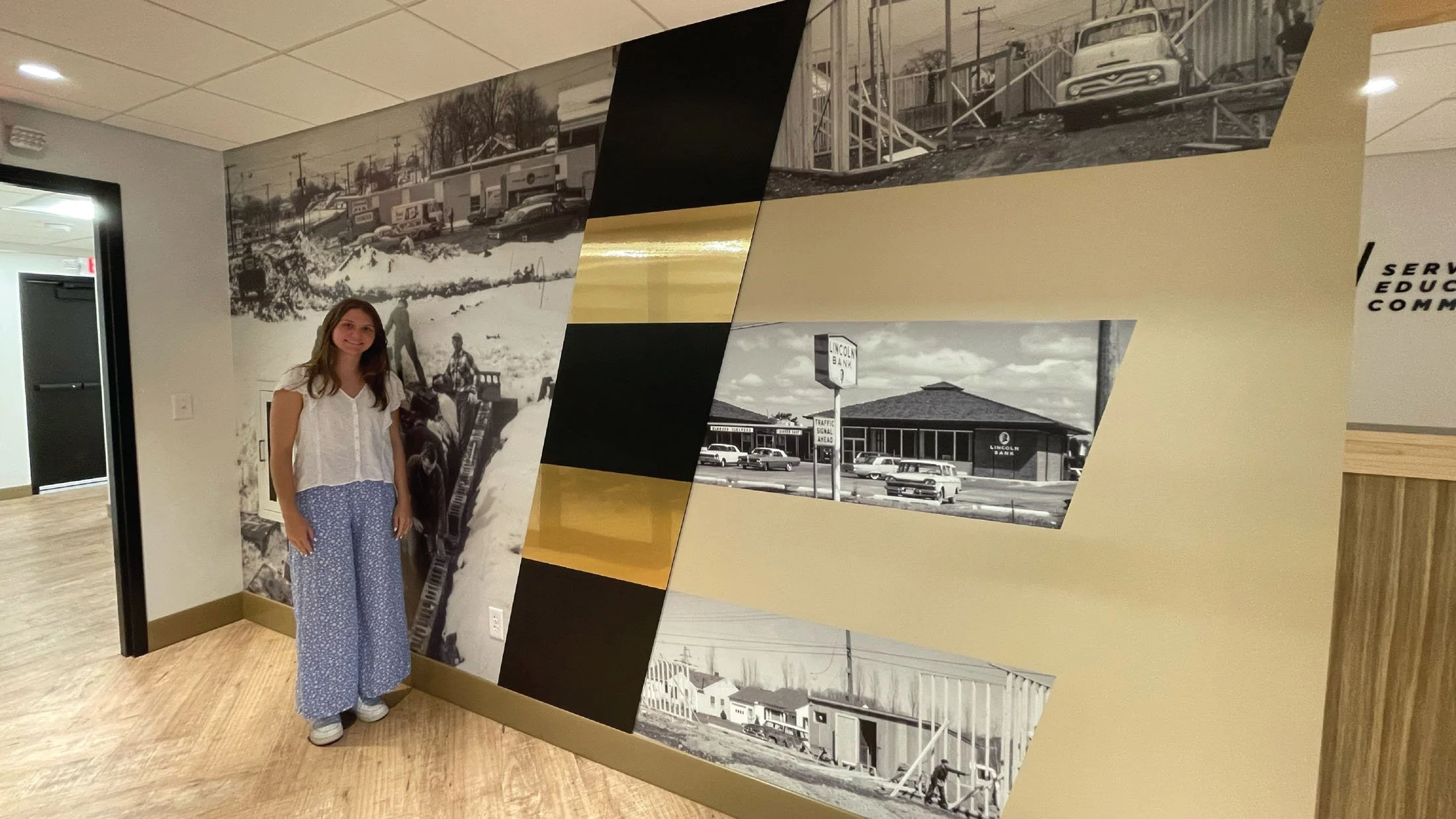 CINSYR | Creative design agency Syracuse, New York | SECNY mortgage services brand identity a woman smiling, standing next to historical "E" wall for scale refernce