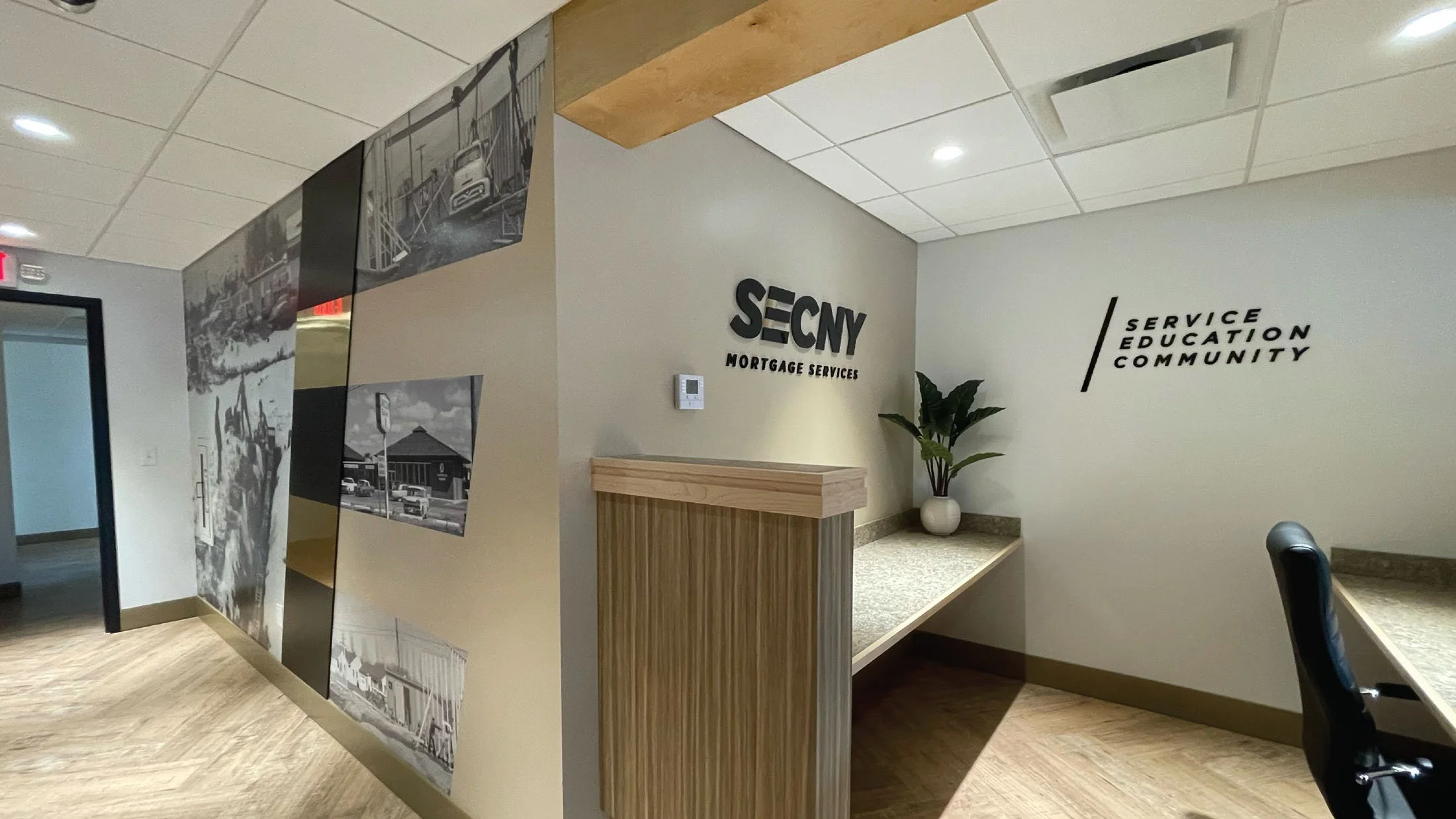 CINSYR | Creative design agency Syracuse, New York | SECNY mortgage services brand identity corner view of front desk and historical "E" wall in the mortgage office