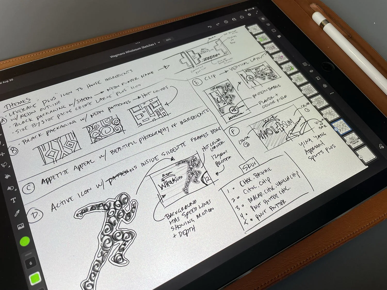 Digital tablet displaying hand-drawn design sketches and notes for home decor and framing, with a stylus resting on its wooden case.