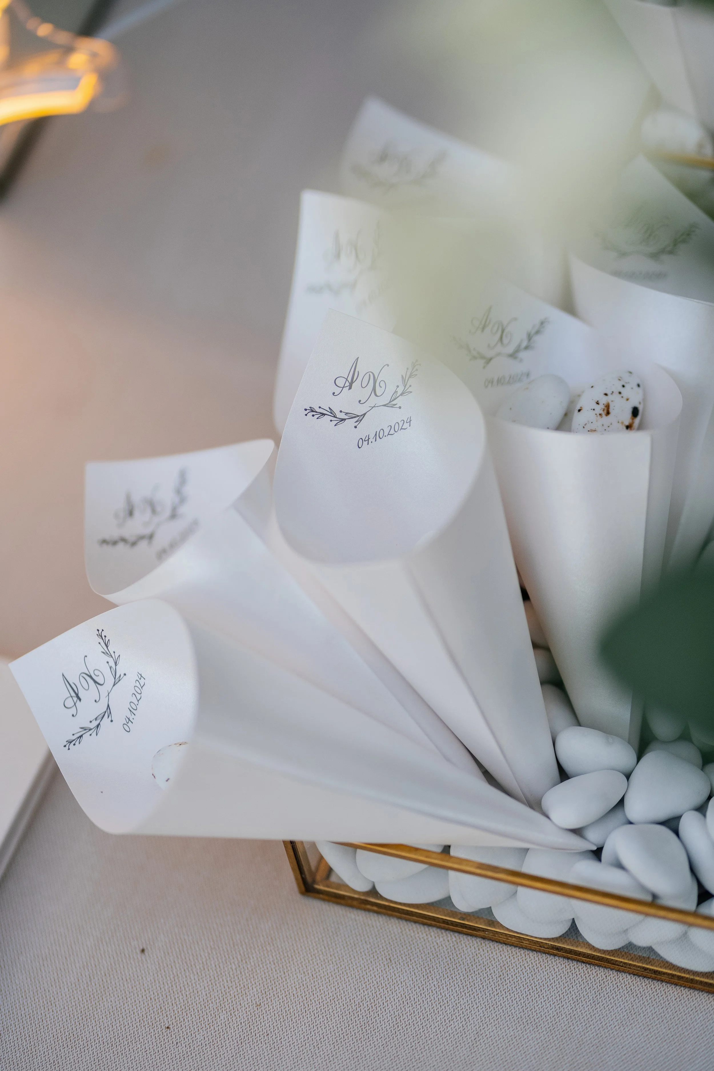 Guest book with white paper pages and a date of 04.10.2024 written on each, surrounded by white decorative stones, placed in a gold framing container.