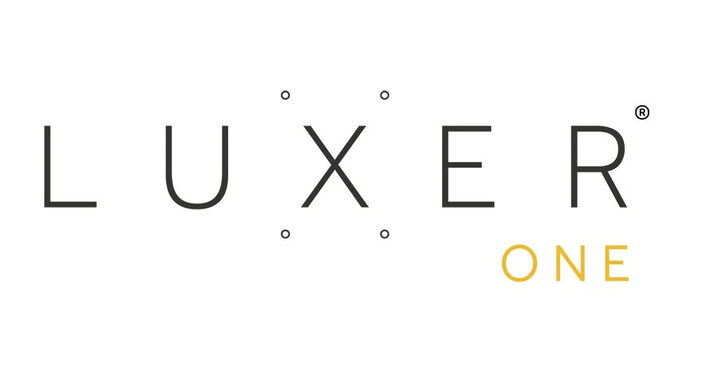 The image displays the text 'LUXER ONE' with 'LUXER' in black capital letters and 'ONE' in yellow capital letters.
