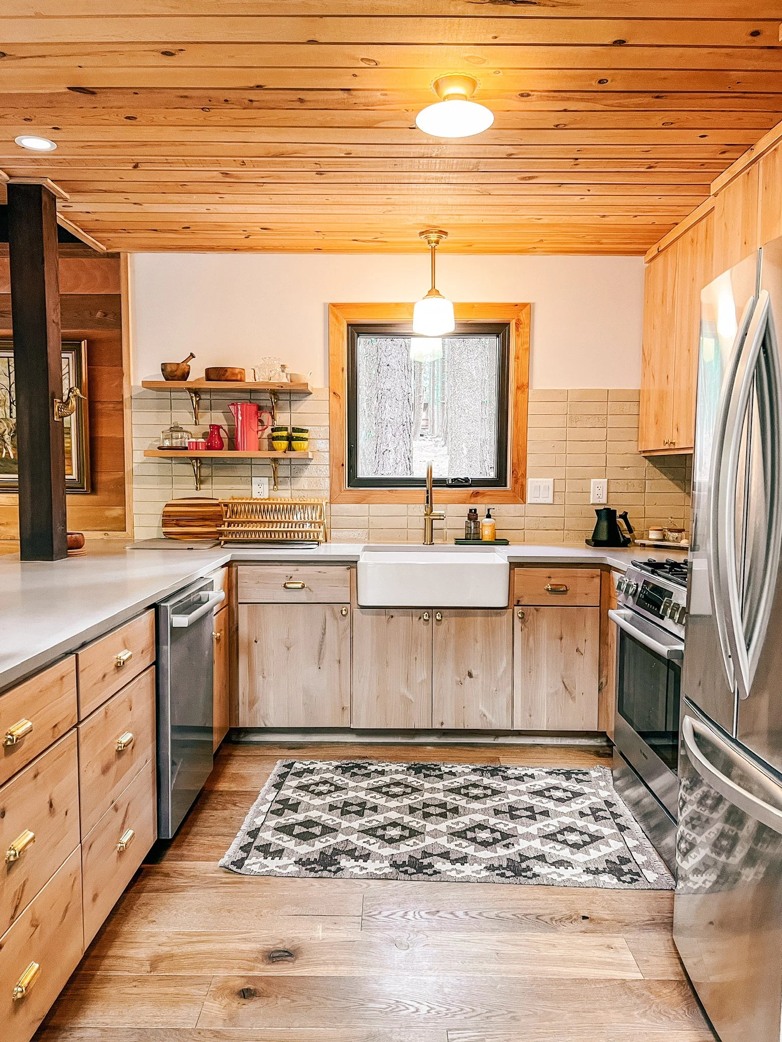 Renovated kitchen includes forest views, a farmhouse sink, gas stove and all the gadgets because the cabin owner is a chef! 