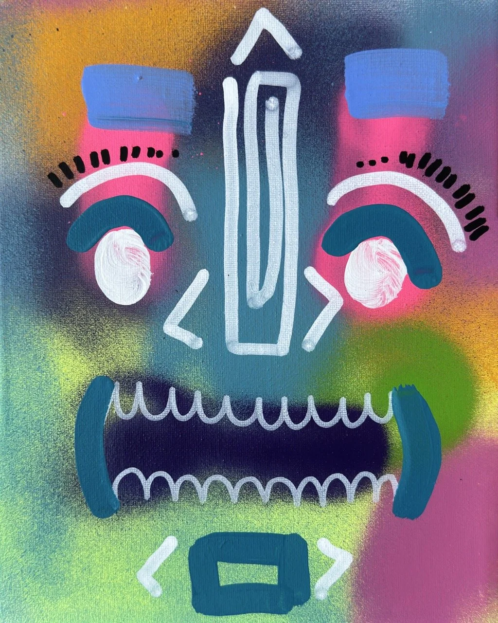 Colorful abstract graffiti art resembling a stylized skull face with bold eye shapes, a nose, and a wide mouth with teeth, on a vibrant, multicolored spray-painted background.
