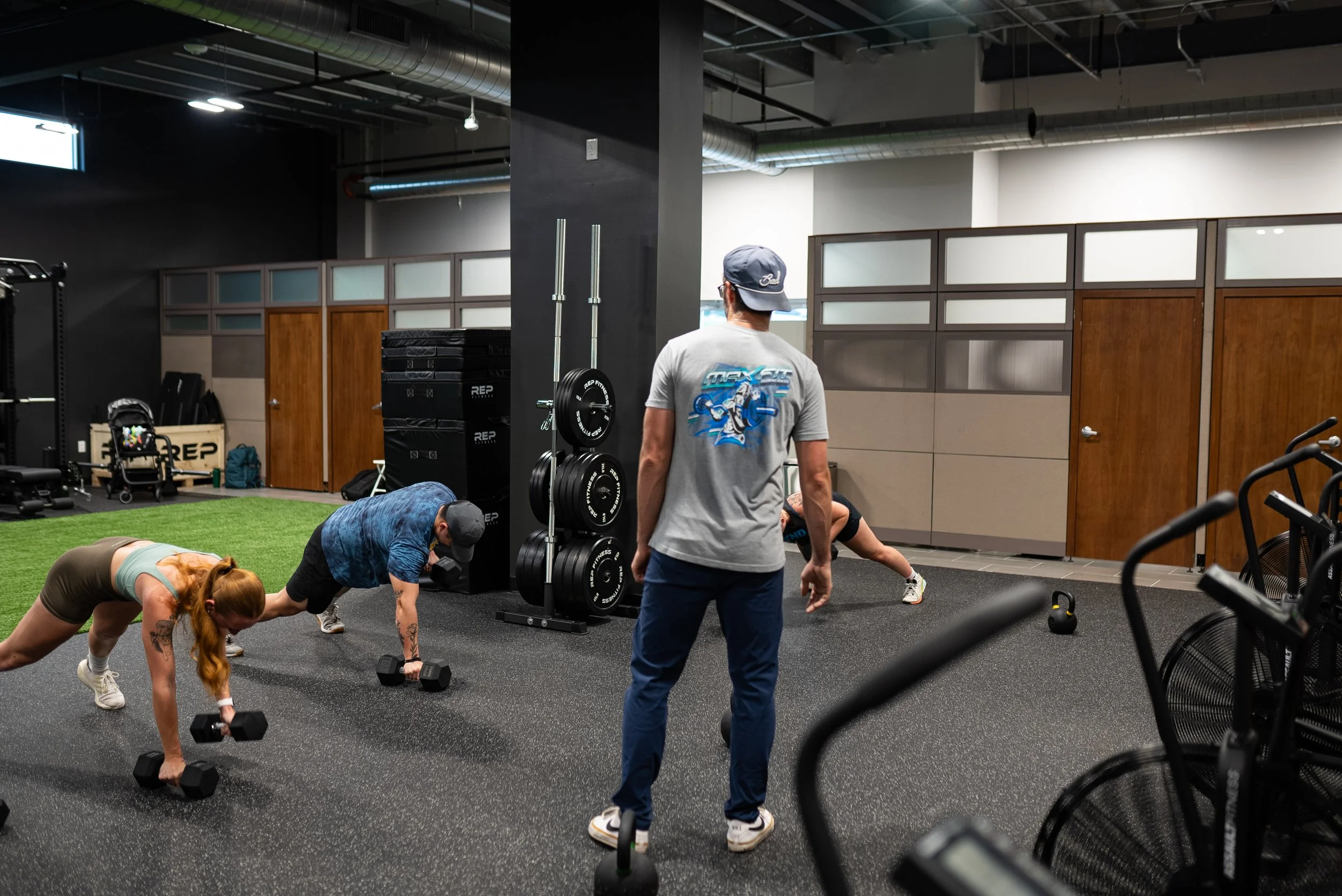 A coached group of MaxxFit adult members training together on the gym floor