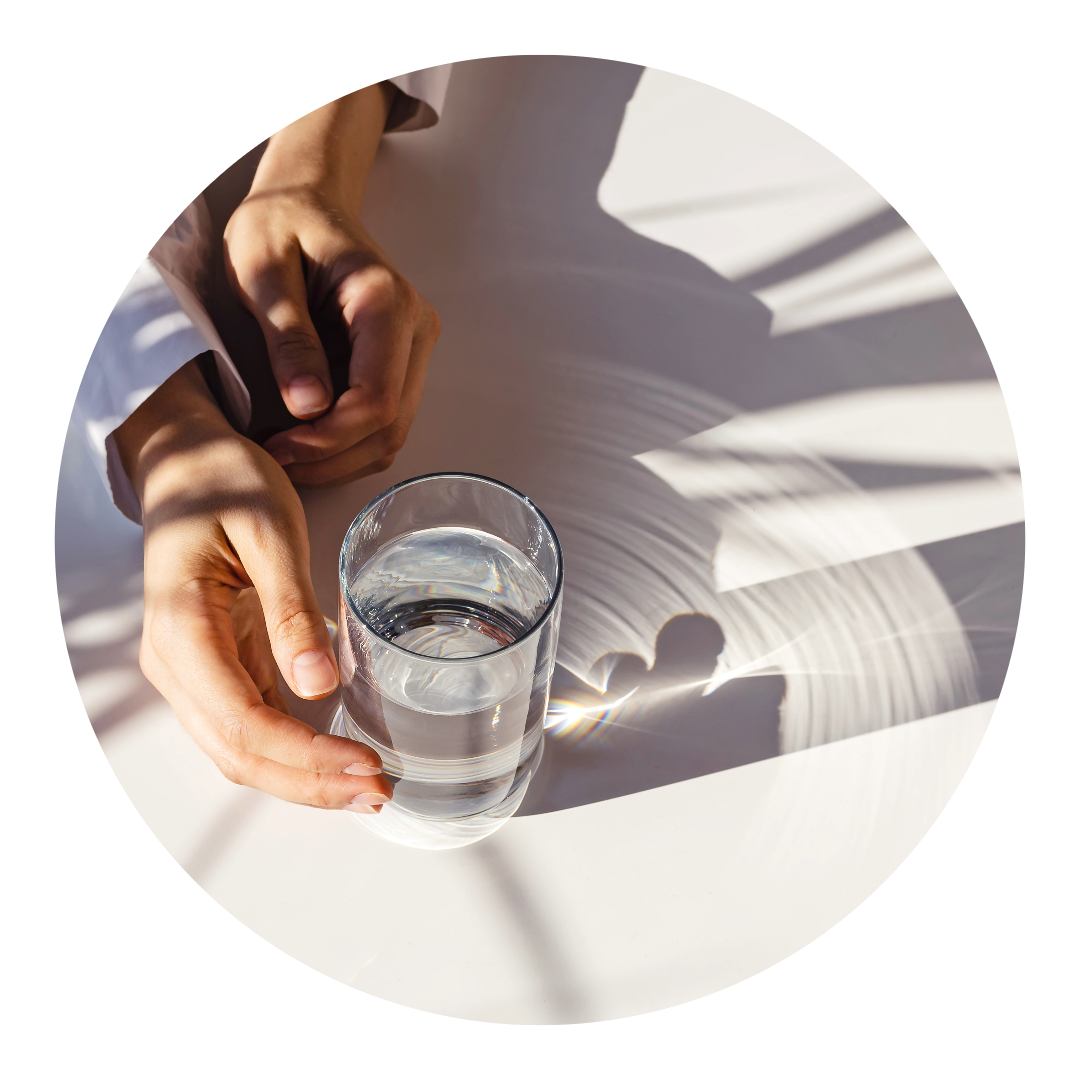 soft hands around a glass of water in the sun