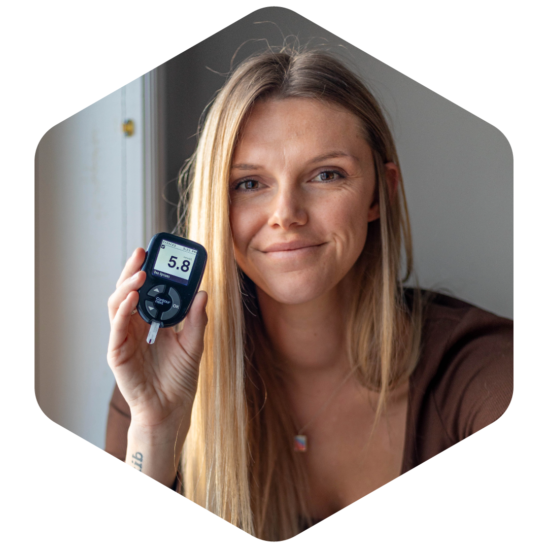 emily holistic nutrition consultant holding up her blood glucose monitor