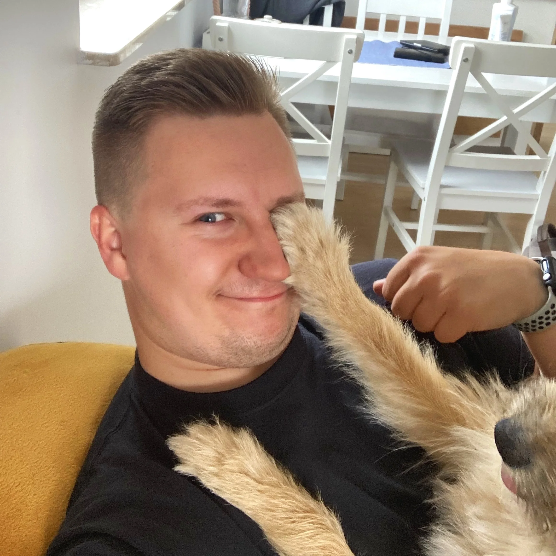 Grzegorz Drozdowski smiling while playing with his dog