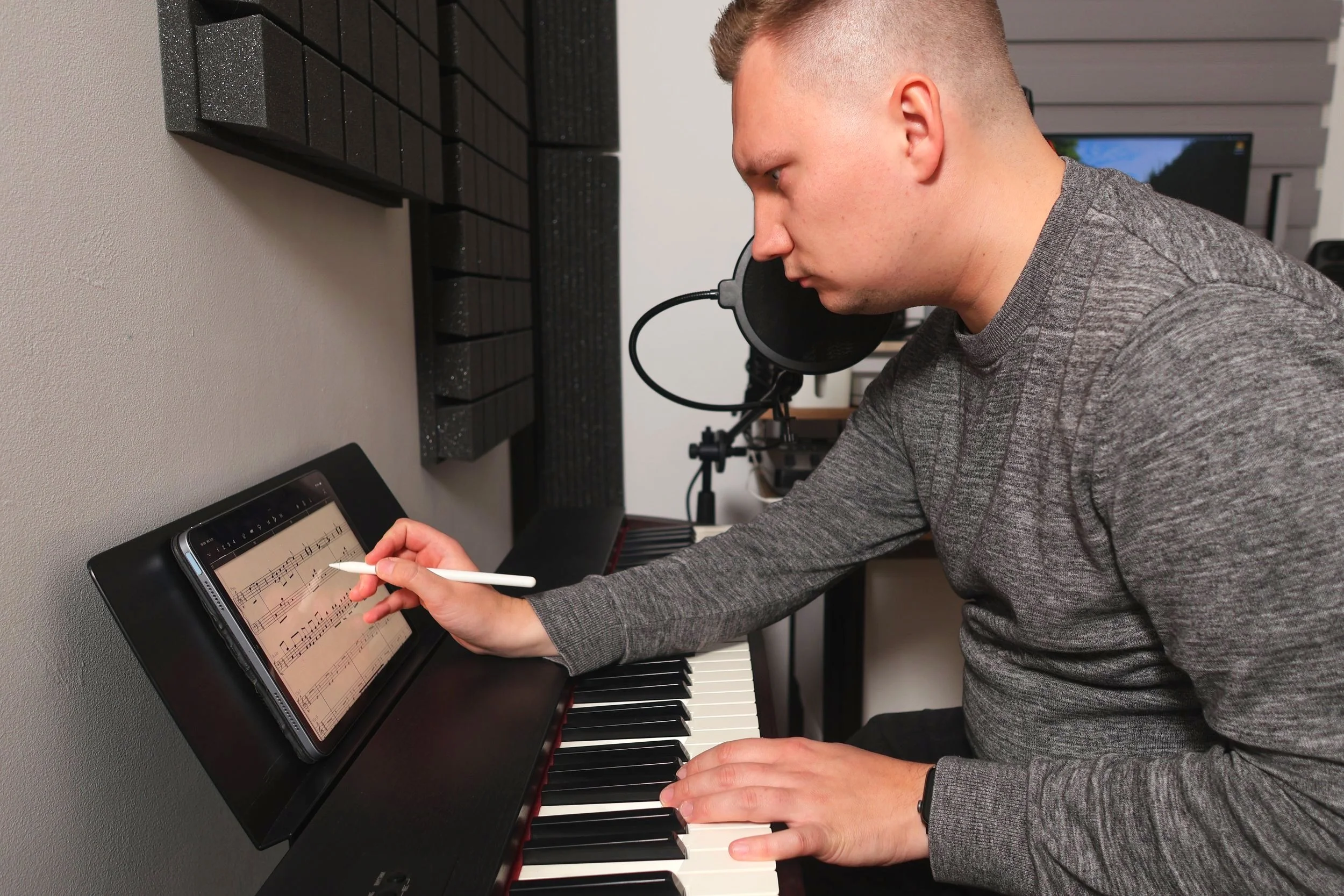 Composer Grzegorz Drozdowski writing music score by the piano
